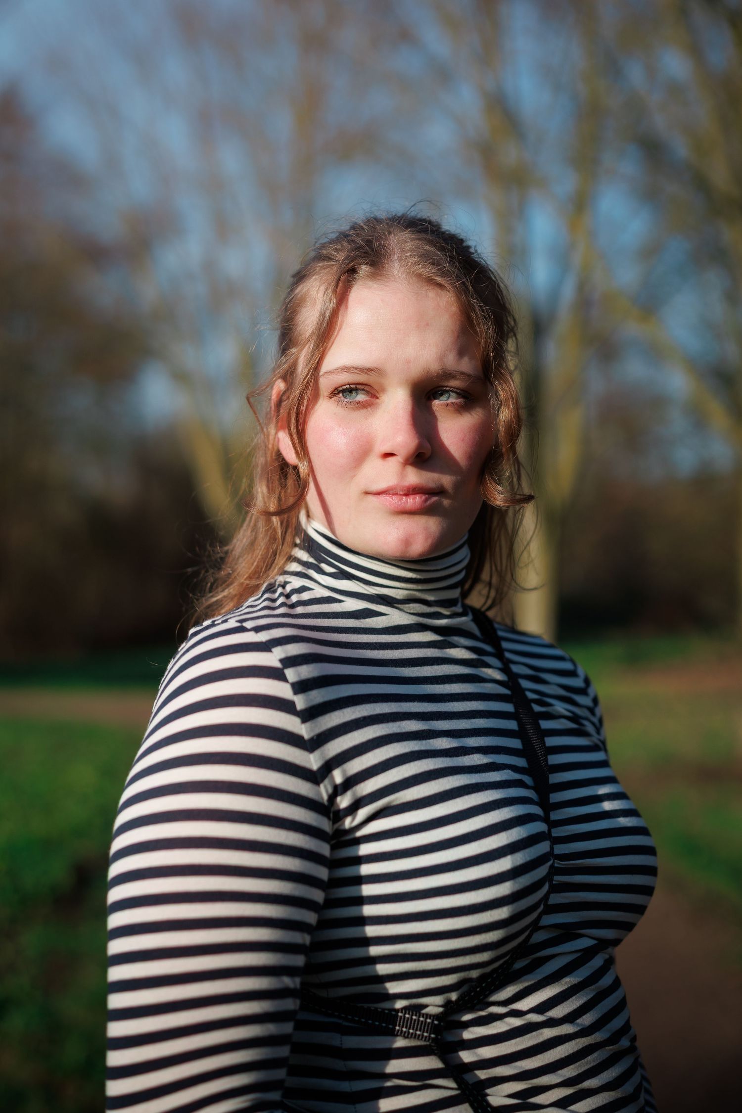 Portretfoto van een vrouw buiten in een park in boskoop, gemaakt met flits en natuurlijk licht, scherpe focus.