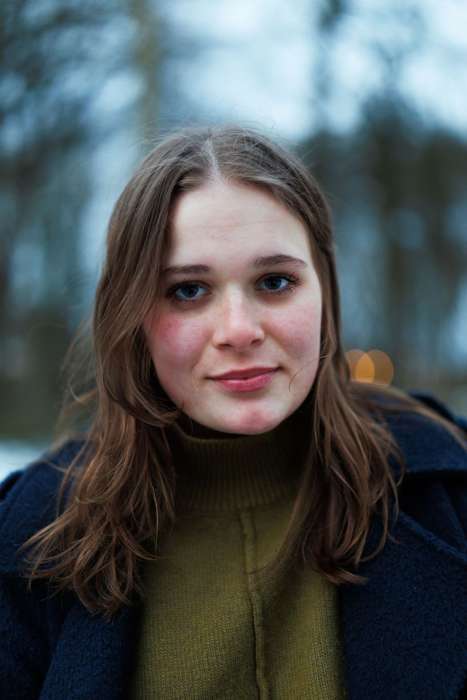 Portretfoto van een vrouw in een winterpark in alphen aan den rijn met sneeuw, vastgelegd met natuurlijk licht.