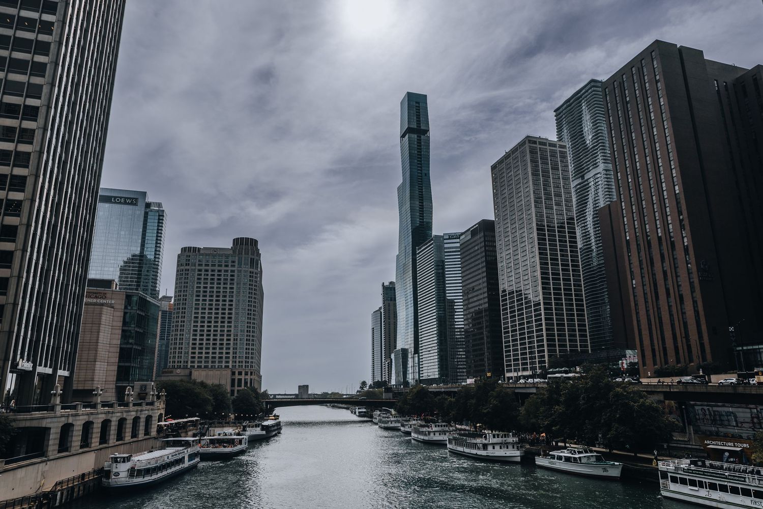 Stadsfoto van de Chicago River met skyline en wolkenkrabbers, gefotografeerd vanaf de rivier bij bewolkt weer.
