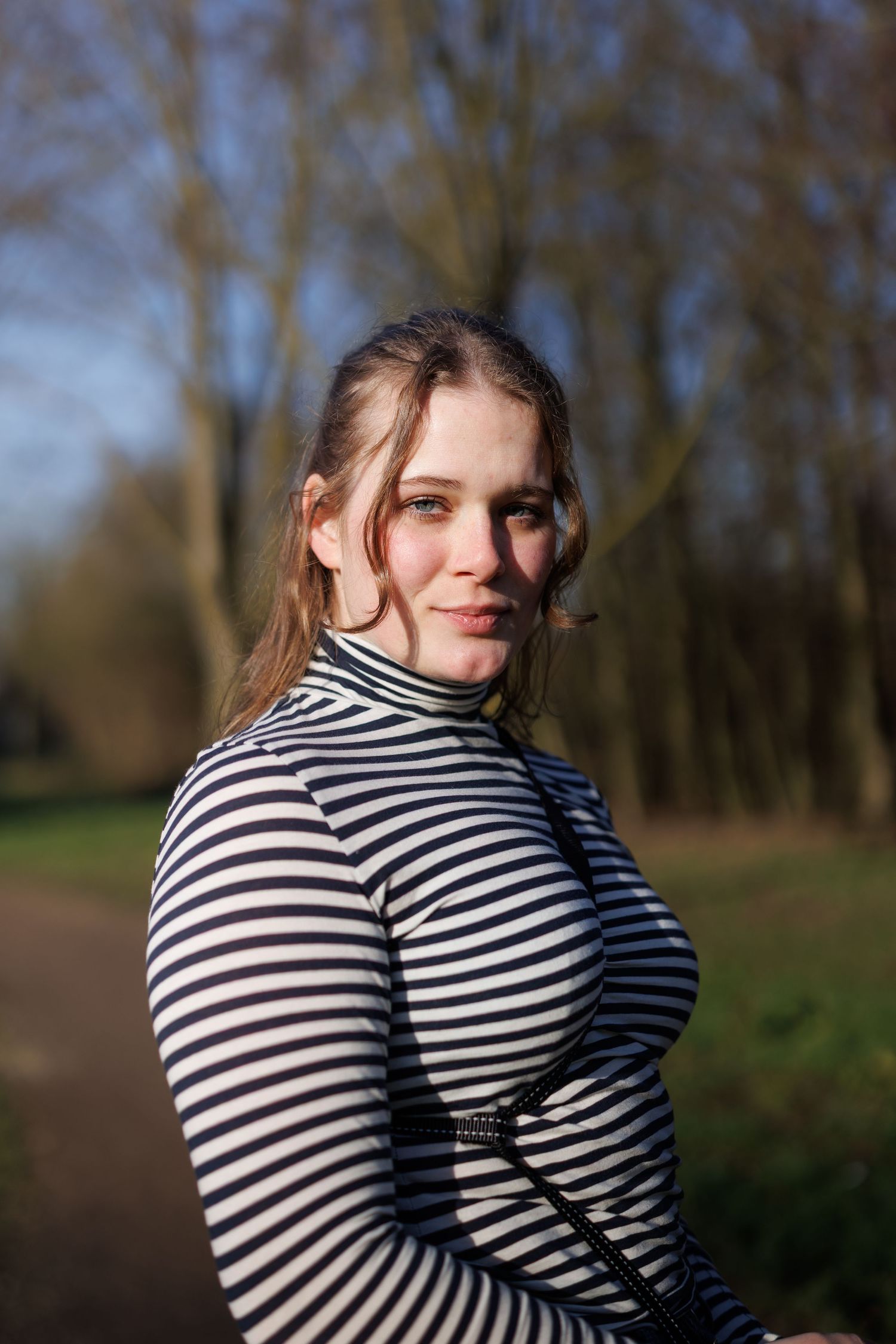 Portretfoto van een vrouw buiten in een park in boskoop, gemaakt met flits en natuurlijk licht, scherpe focus.