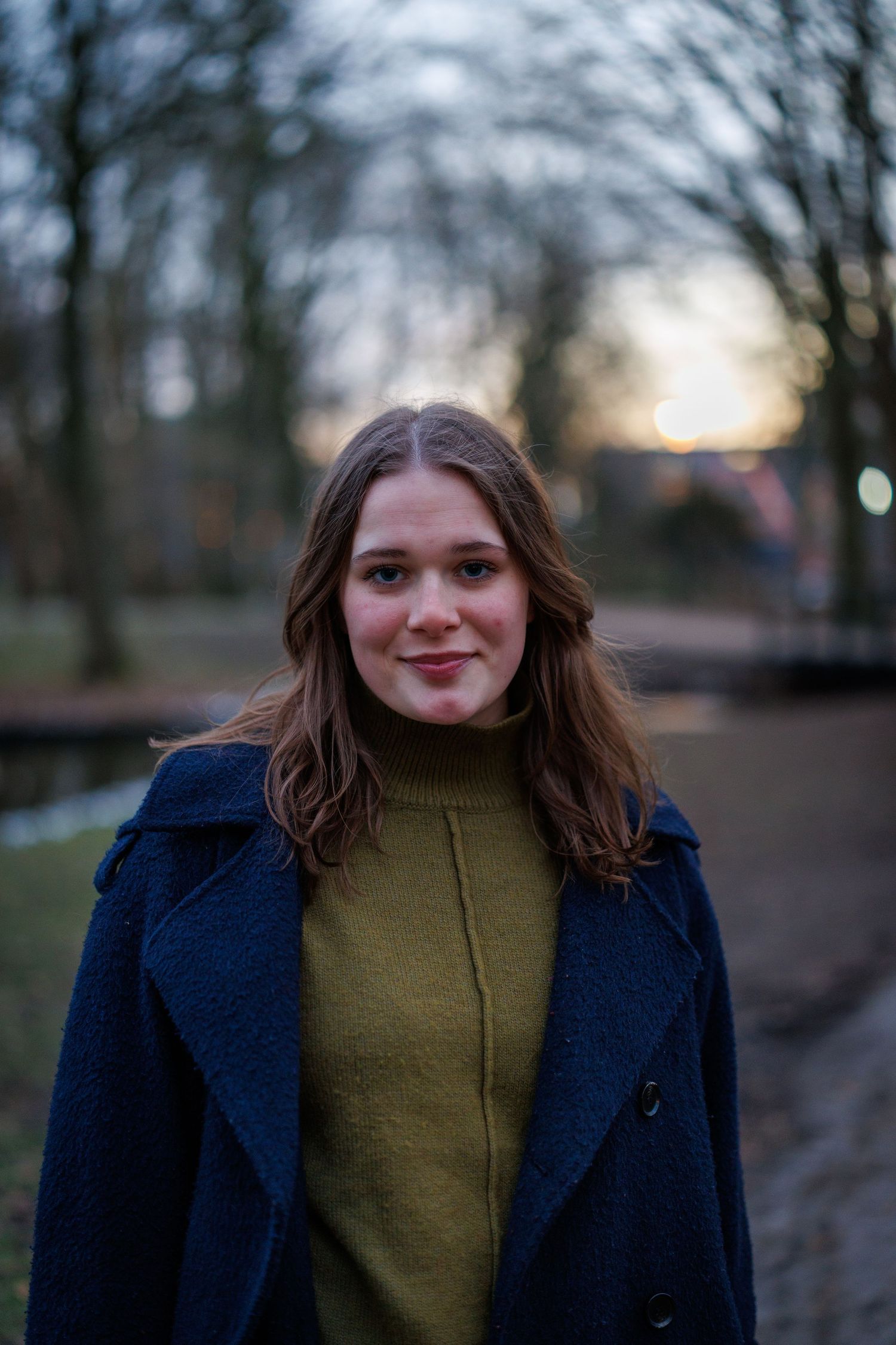 Portretfoto van een vrouw in een winterpark in alphen aan den rijn met sneeuw, vastgelegd met natuurlijk licht.