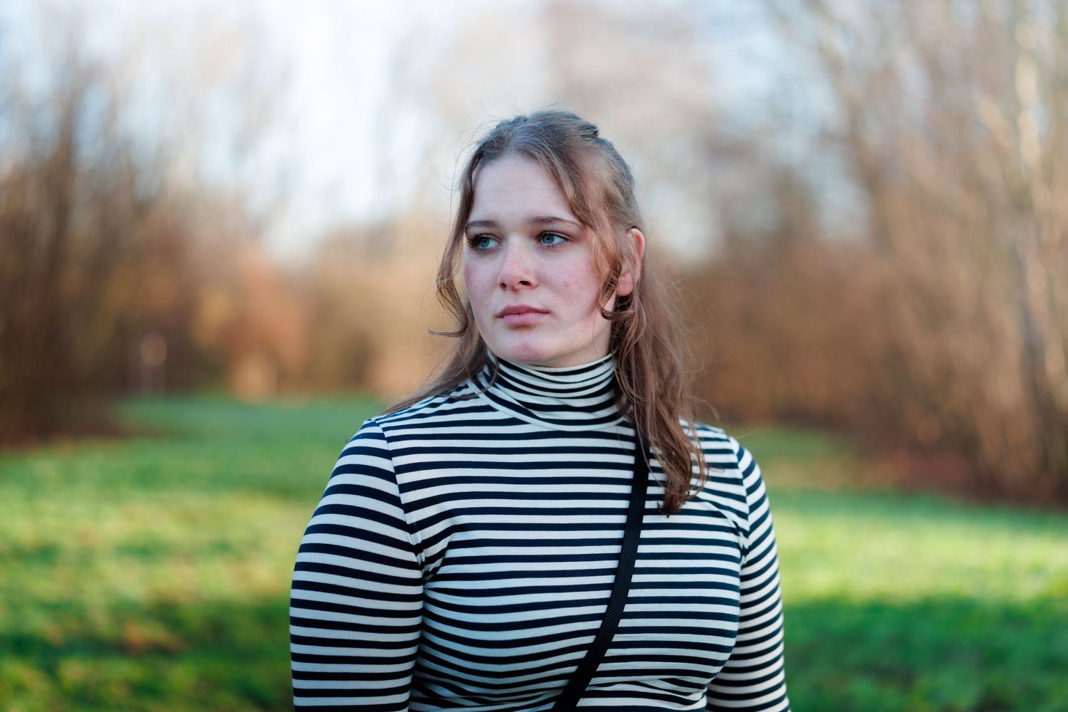 Portretfoto van een vrouw buiten in een park in boskoop, gemaakt met flits en natuurlijk licht, scherpe focus.
