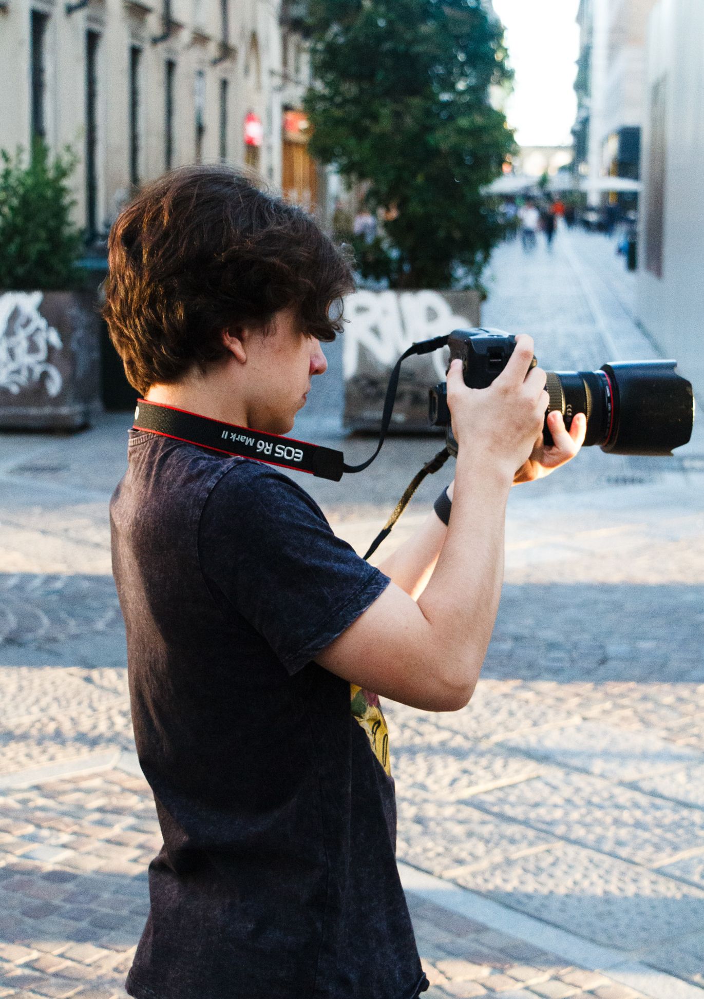 Fotograaf maakt straatfoto’s met een professionele camera in een stedelijke omgeving met natuurlijk licht.