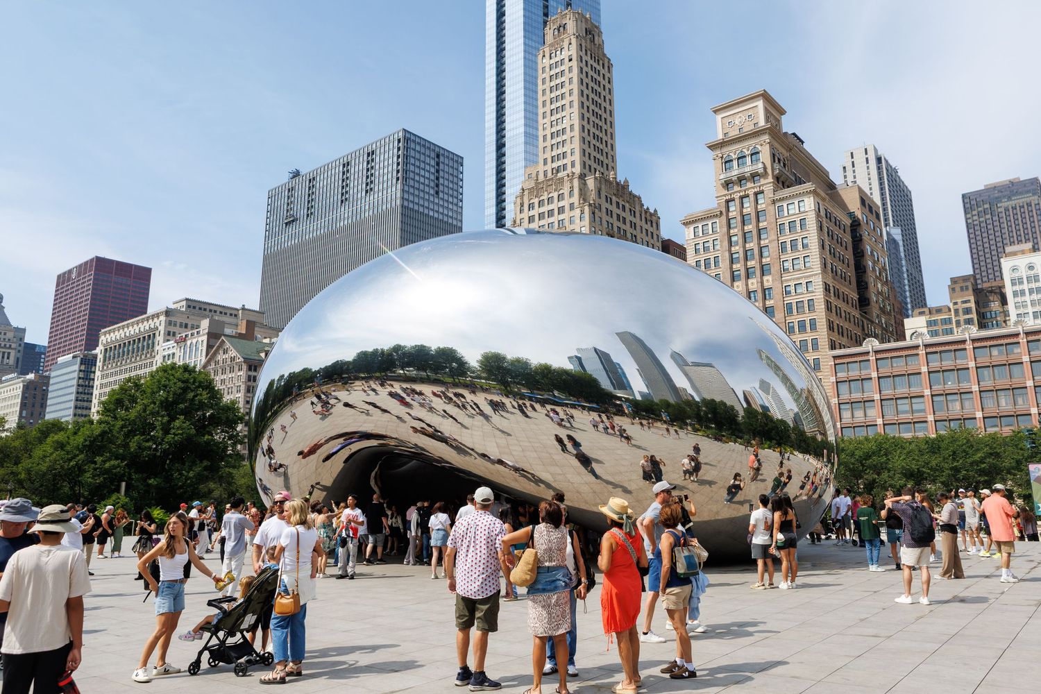 Stadsfoto van Cloud Gate (The Bean) in Chicago, met reflecties van wolkenkrabbers en bezoekers op het plein.