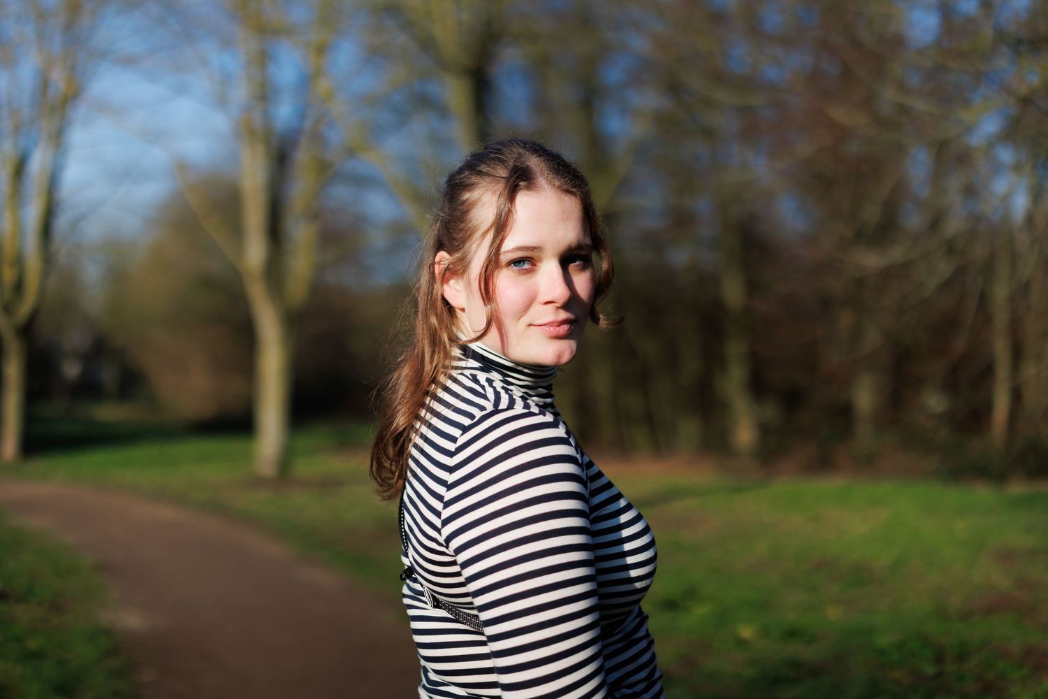 Portretfoto van een vrouw buiten in een park in boskoop, gemaakt met flits en natuurlijk licht, scherpe focus.