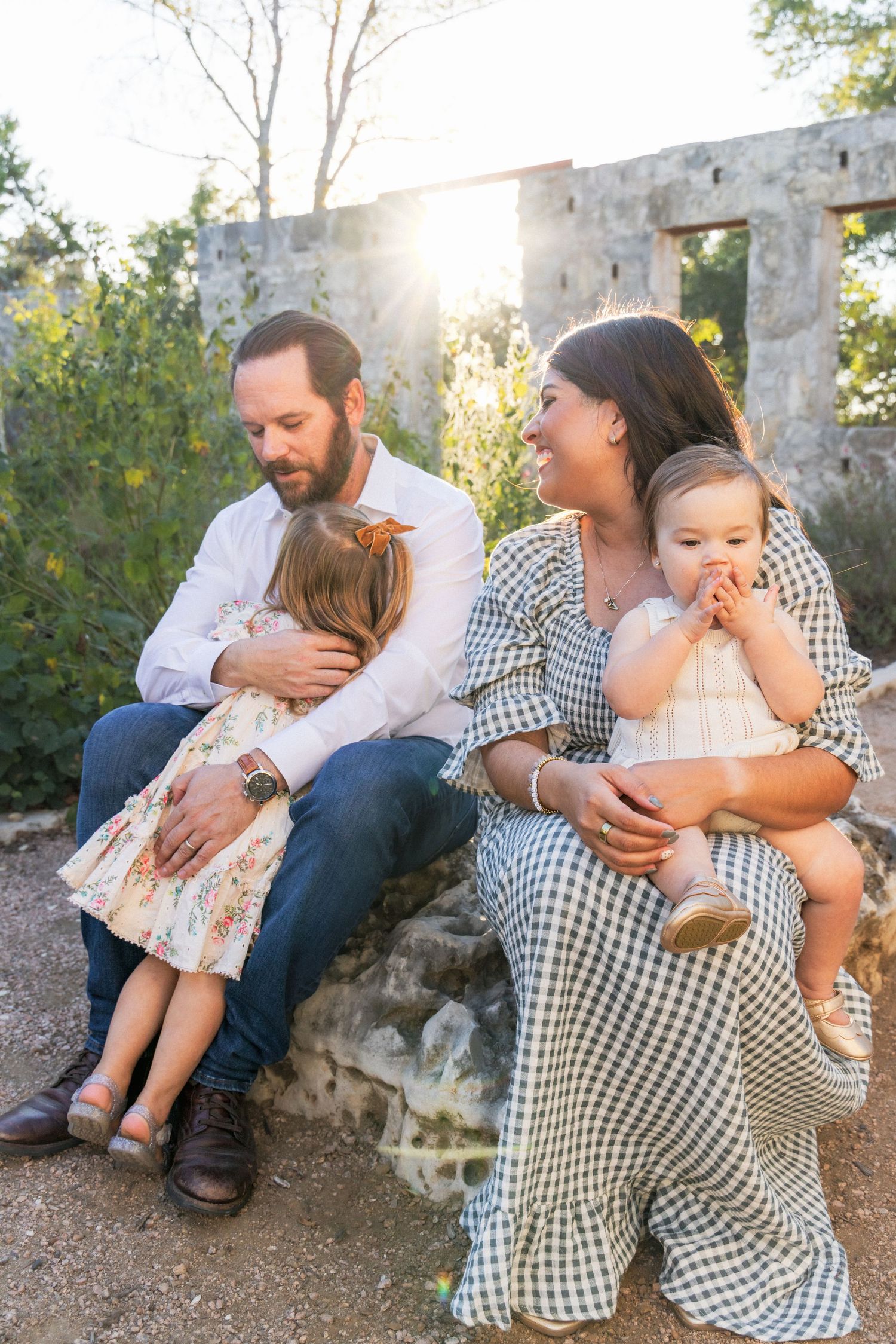 Dad and mom hug daughters during candid family photography session | Dripping Springs, Texas Hill Country