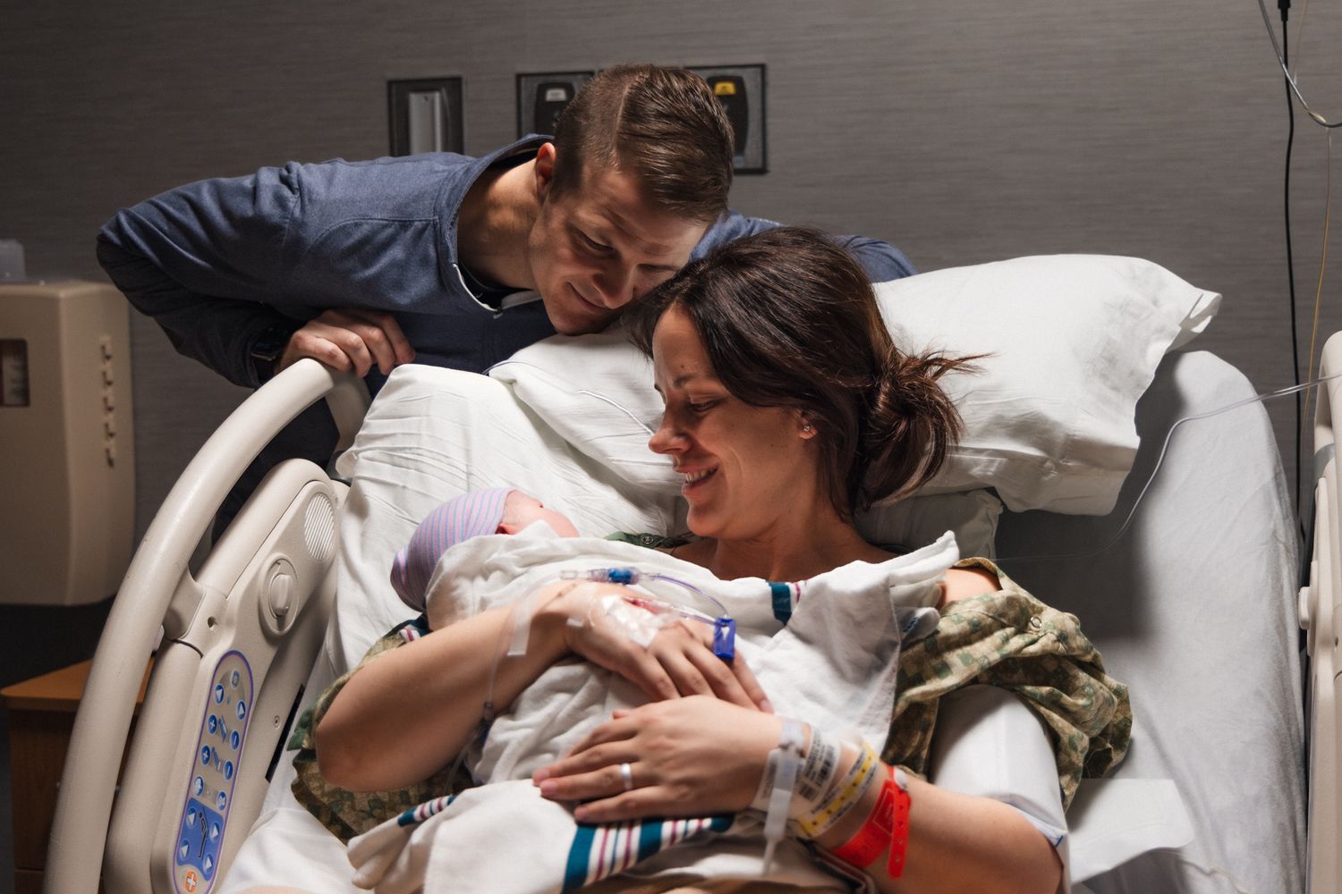 Husband and wife gaze at newborn baby in hospital after birth | Birth Photography Austin Texas
