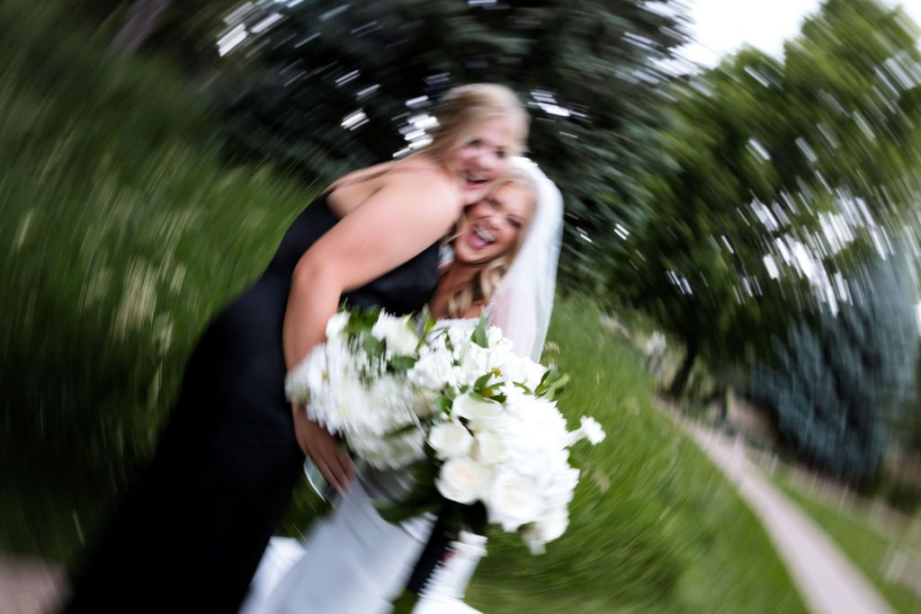 Bride and bridesmaid celebrating during bridesmaids portraits | Fun bridesmaid photos | Outdoor Colorado wedding