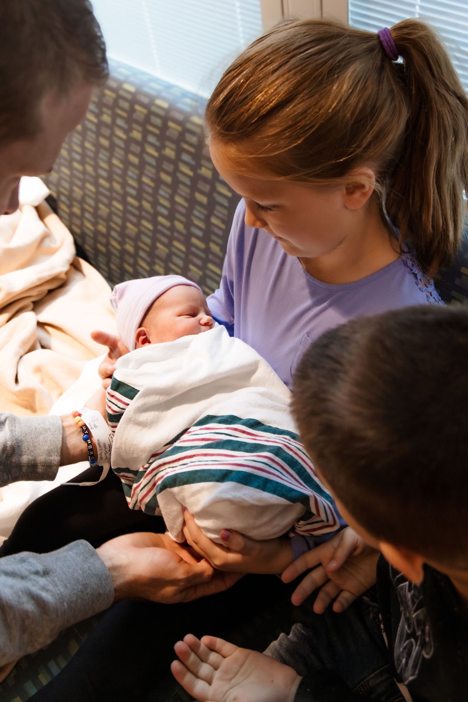 Siblings meet the new baby of the family at the hospital in Austin, Texas