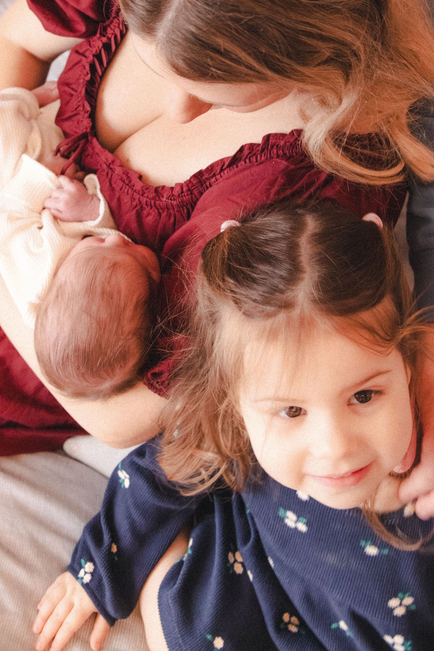 Mom holds newborn baby with toddler during candid newborn family photography session