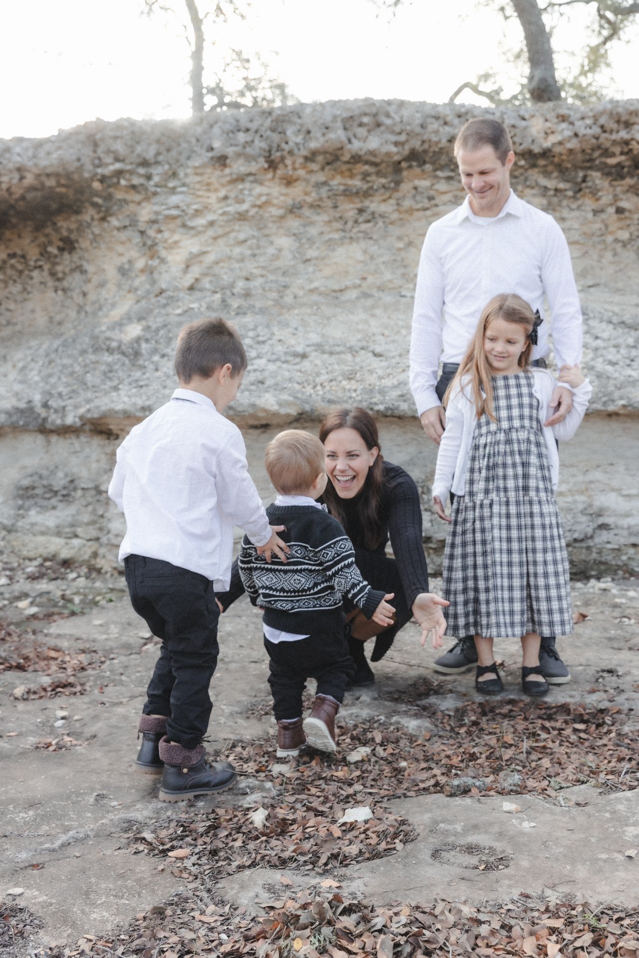 Son runs to mom during outdoor family photography session in Dripping Springs, Texas