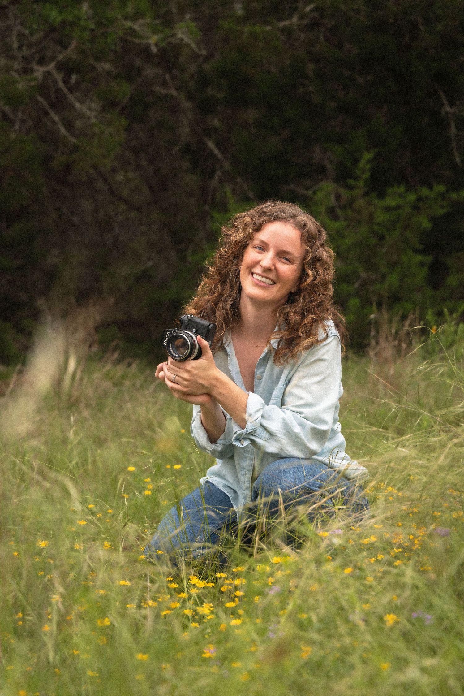 Photographer holds vintage camera in field of yellow wildflowers | Maddy Wilson, Wandering Wilsons Photography