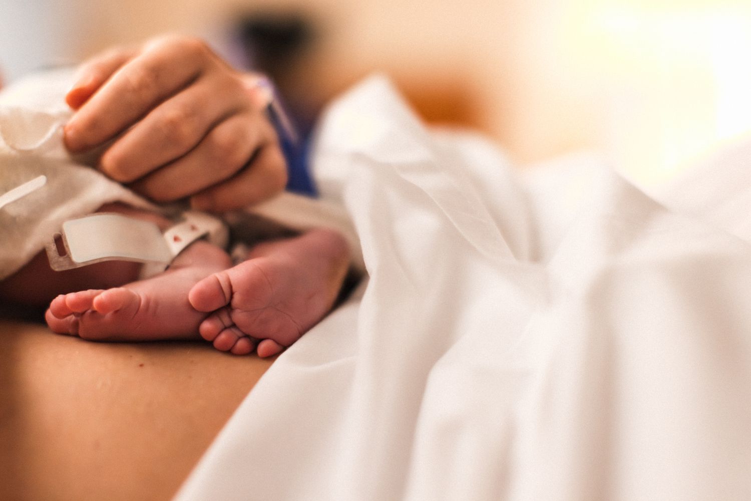 Newborn baby's feet details laying on mom right after hospital birth | birth photography Austin Texas