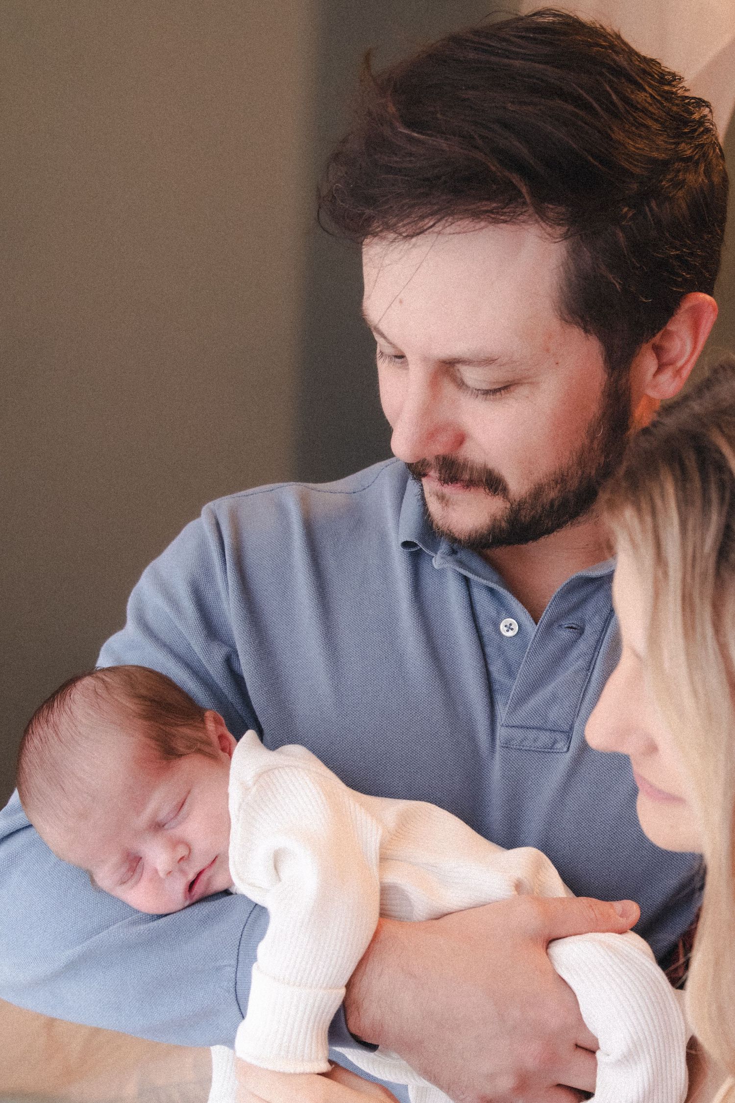 Dad holds newborn baby in at-home newborn session