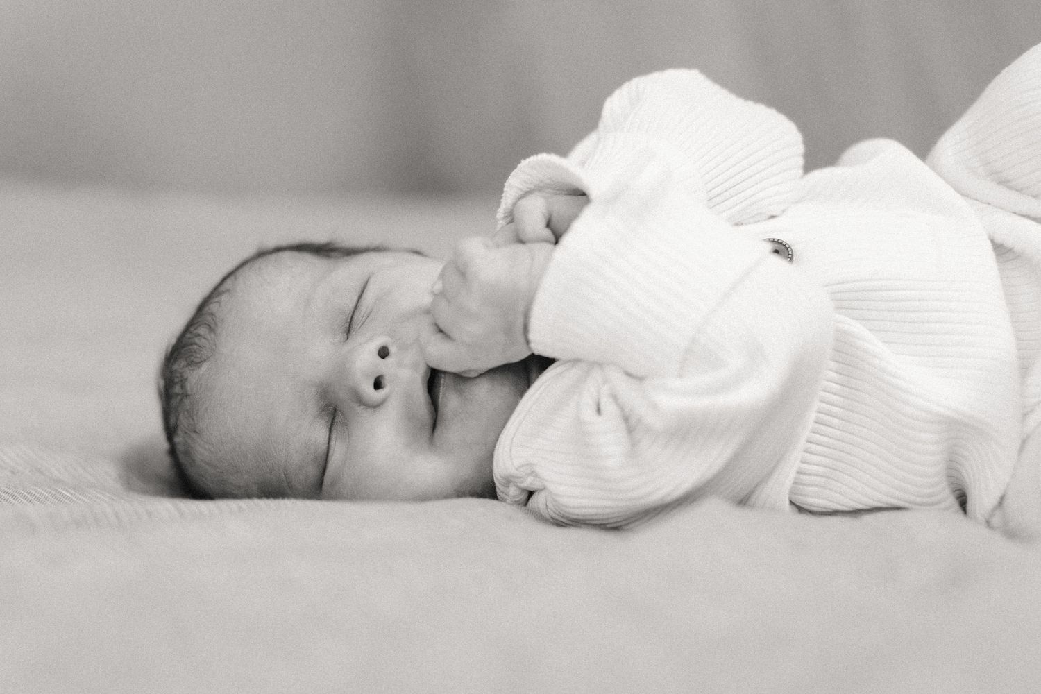 Newborn baby sleeps on bed at home in Austin, Texas