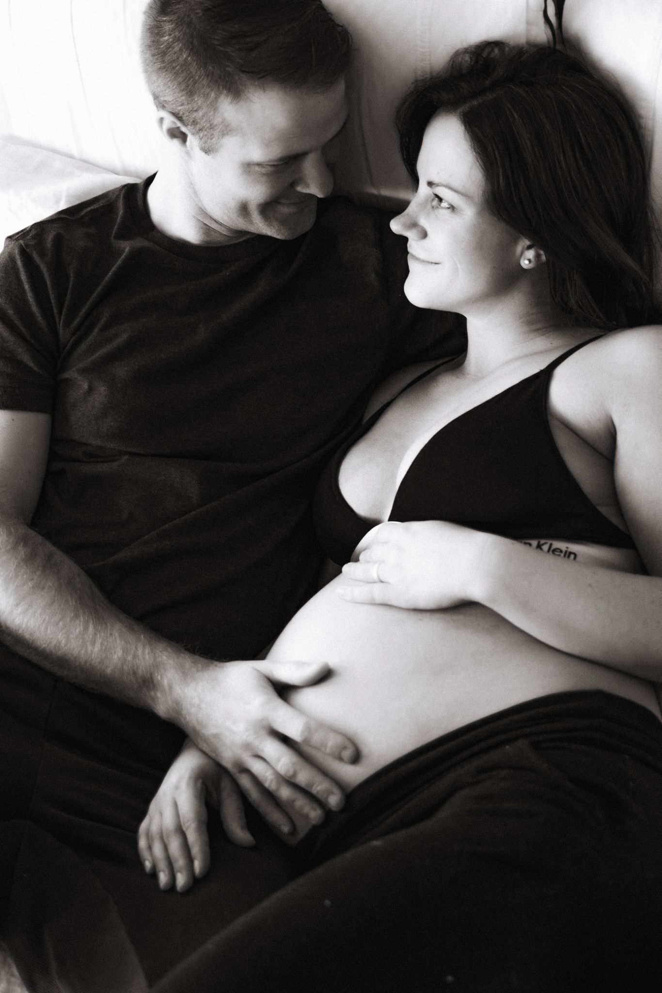 Husband cuddling pregnant wife during at-home maternity session