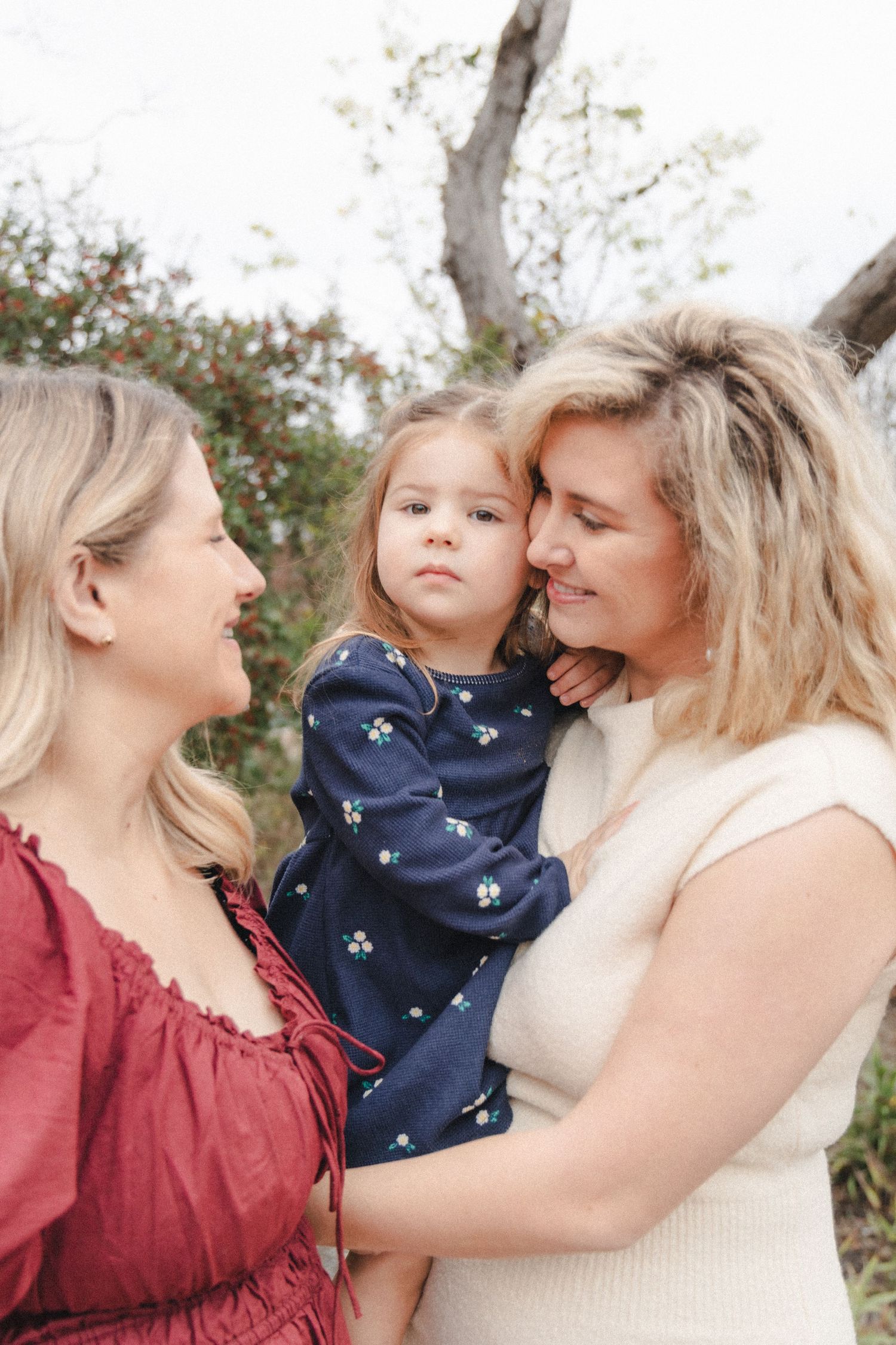 Aunt holds niece during outdoor extended family photography session