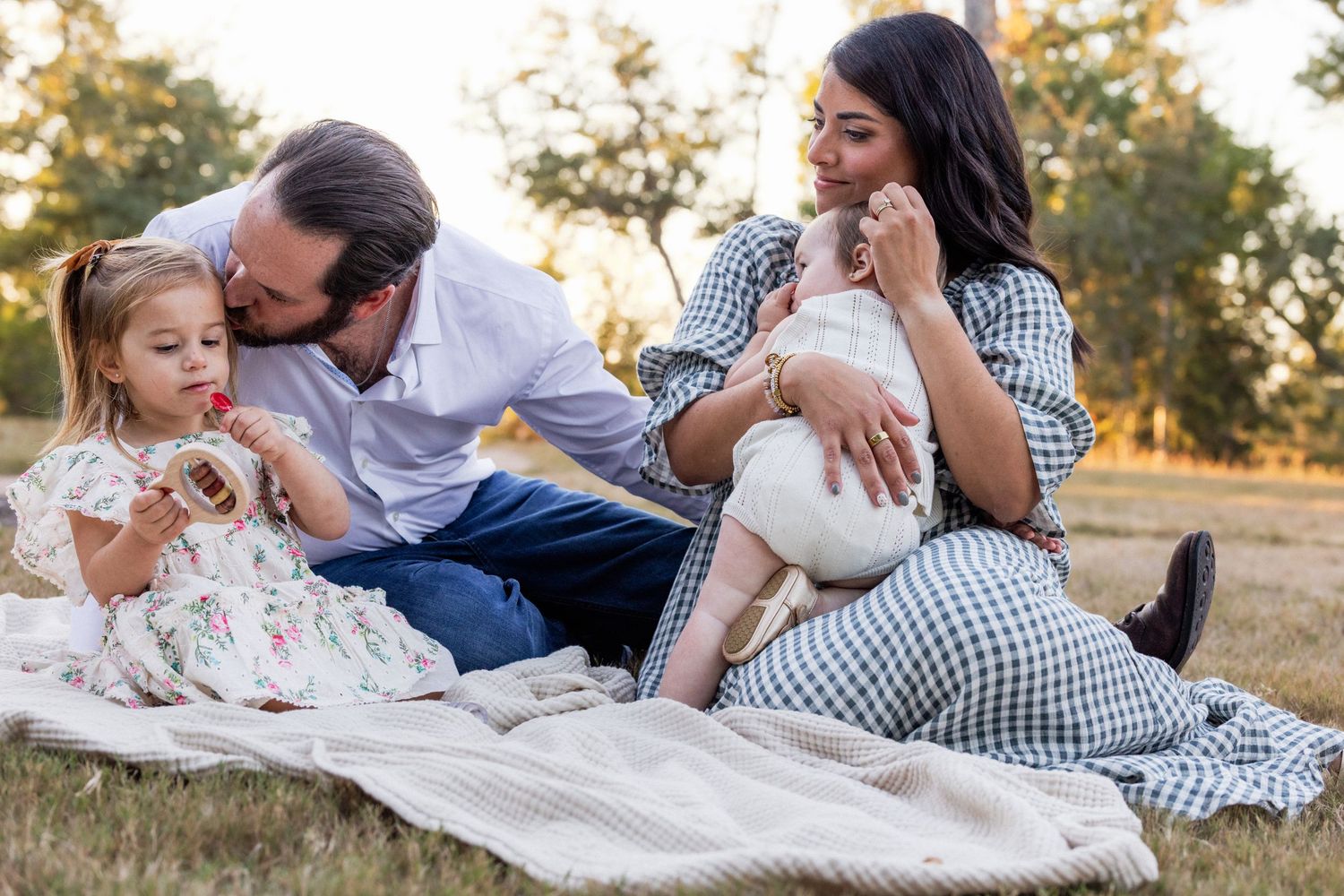 Family embraces on blanket during outdoor family photography session