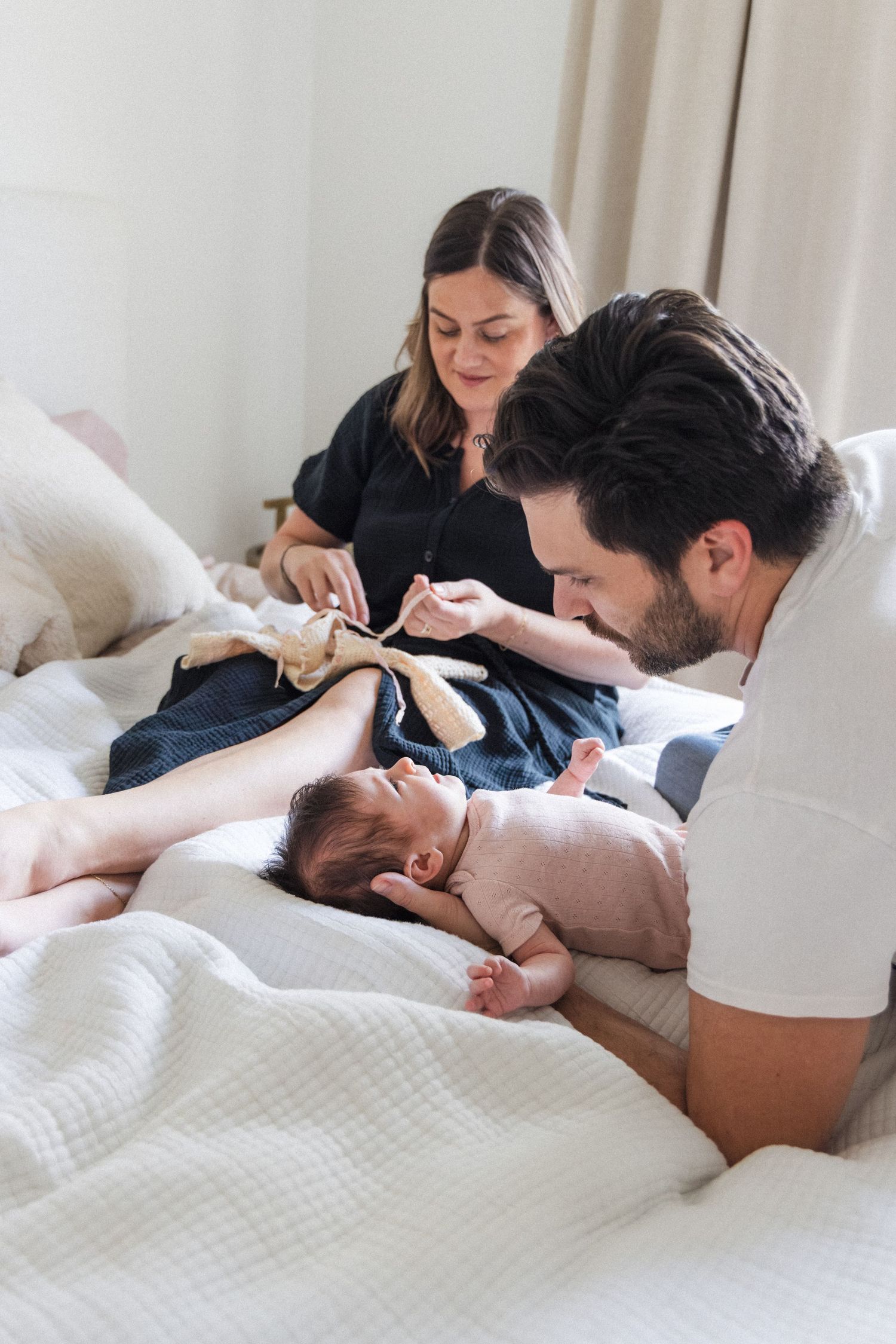 Couple changes newborn baby on their bed at home in Austin, Texas