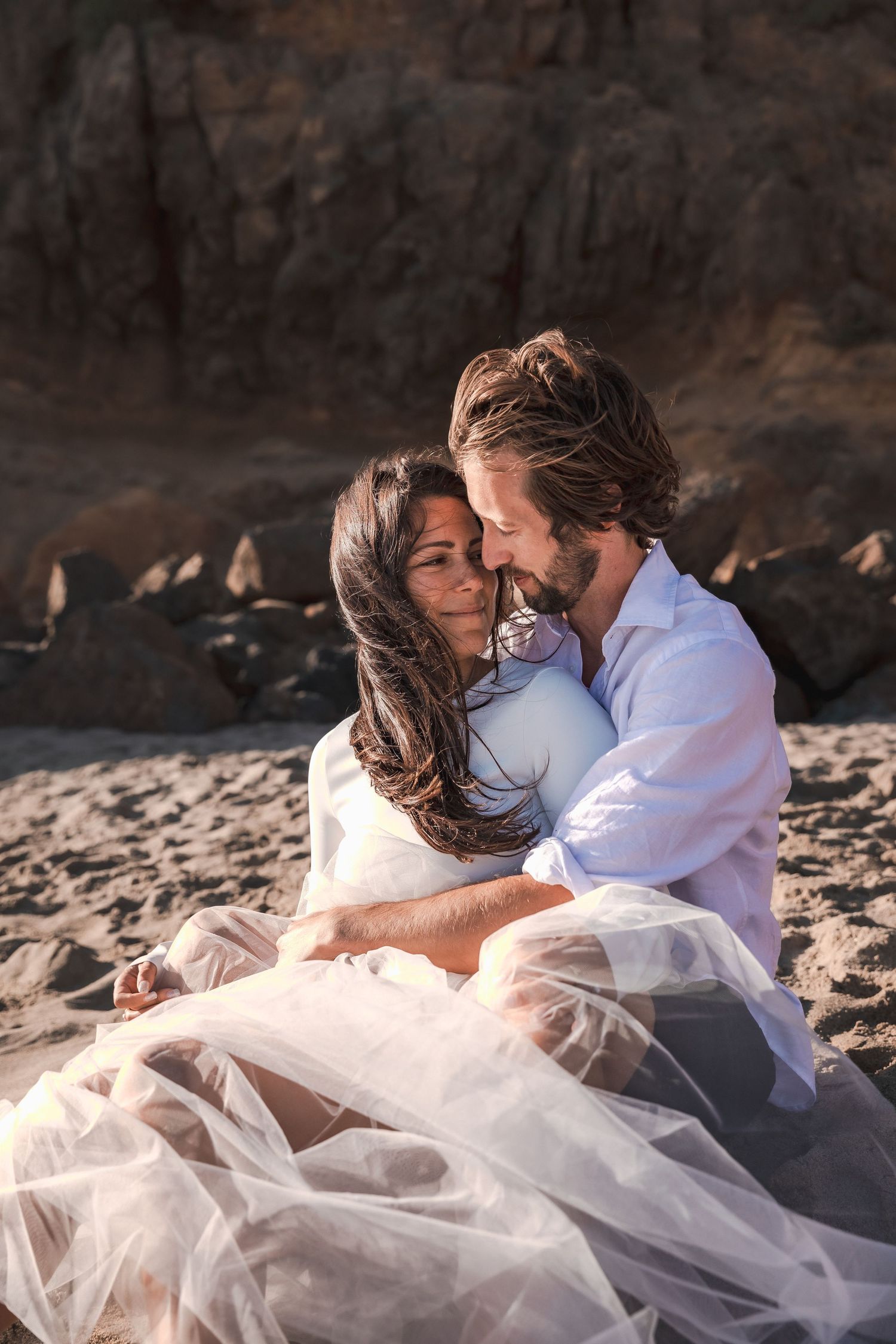 Couple cuddles on the beach during elopement shoot | Malibu, California | Couples Travel Portrait Sessions