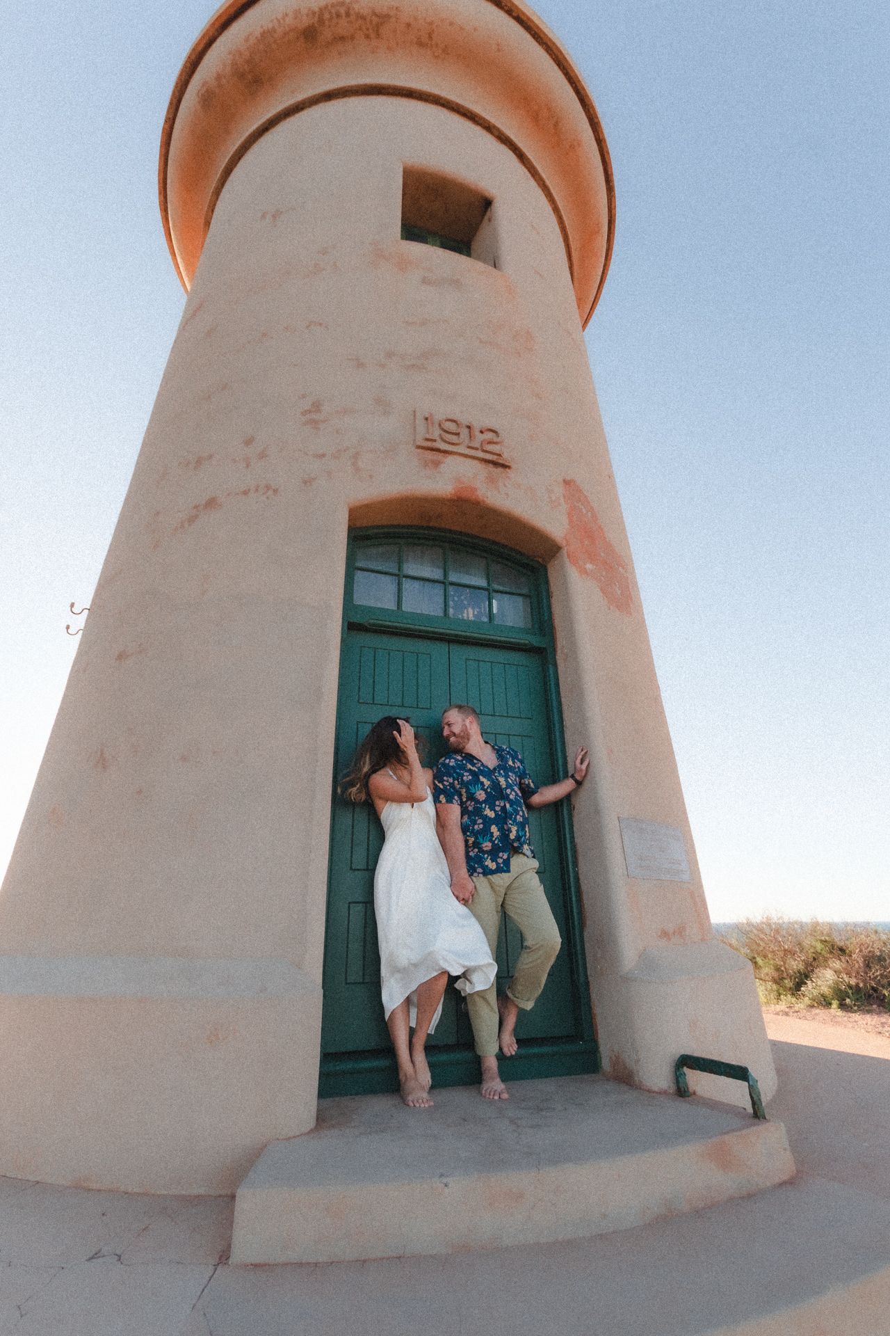 Couple photos at lighthouse during casual beach elopement