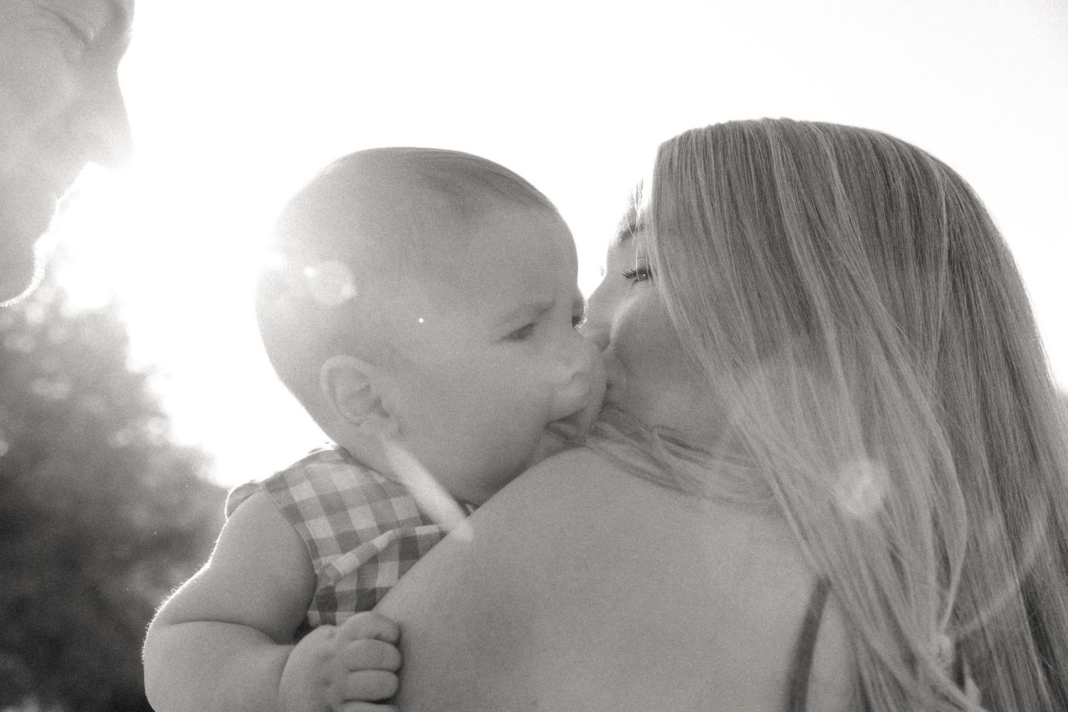 Mother embracing baby boy at sunrise in the Texas Hill Country.