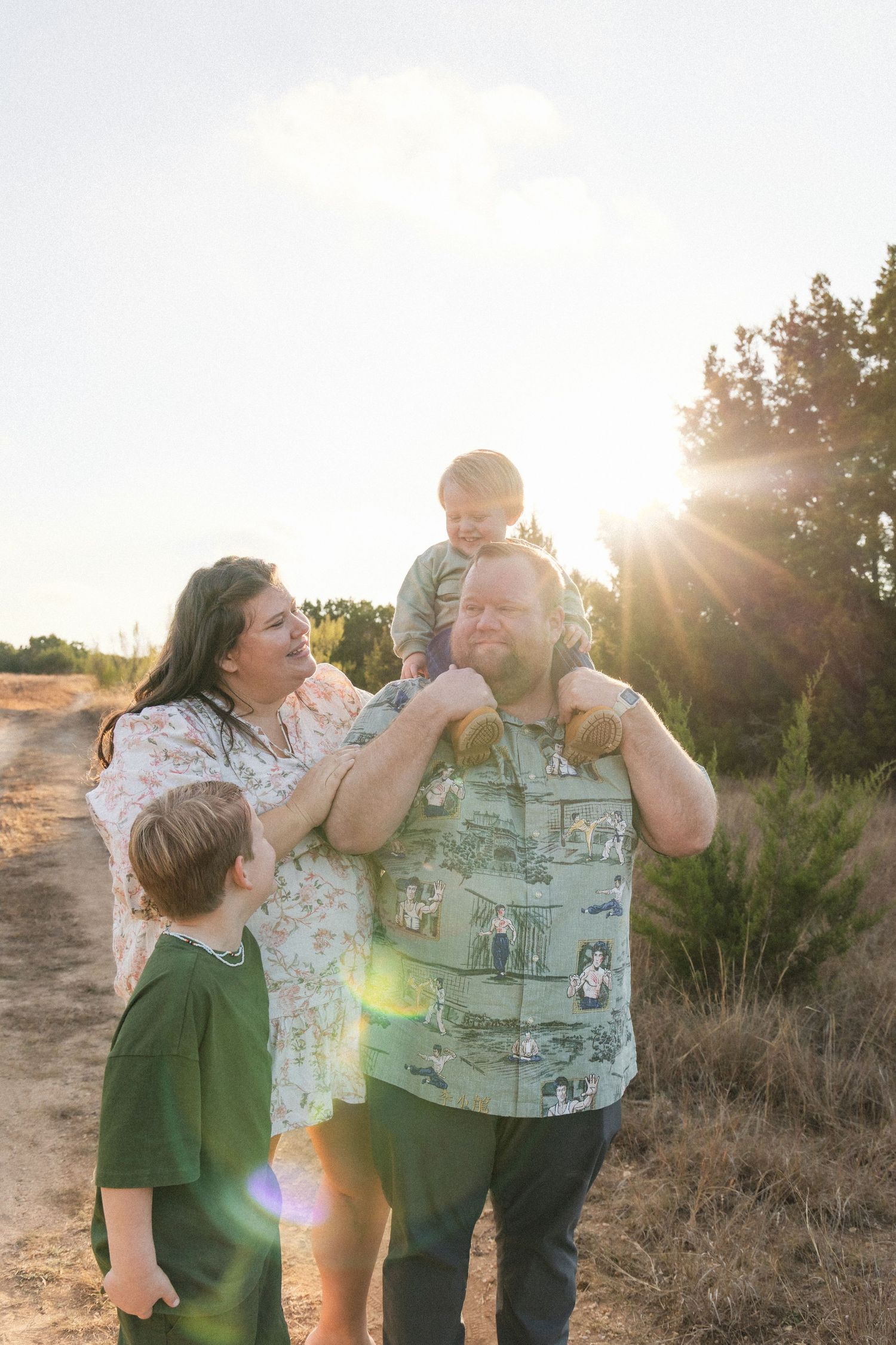 Family plays together at sunset outdoor family photography session in Dripping Springs, Texas