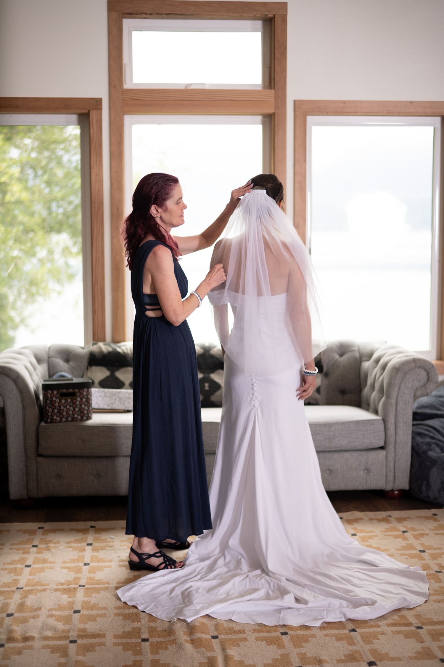 Wedding dress preparation scene with flowing white train in sunlit room.
