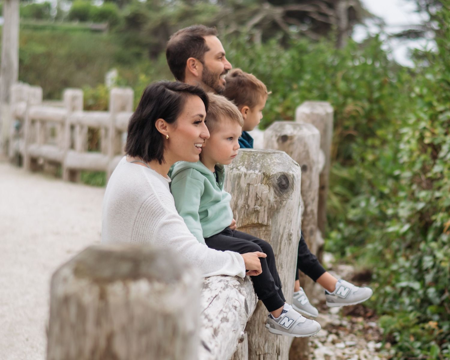Casual family moment captured on rustic wooden bench outdoors.