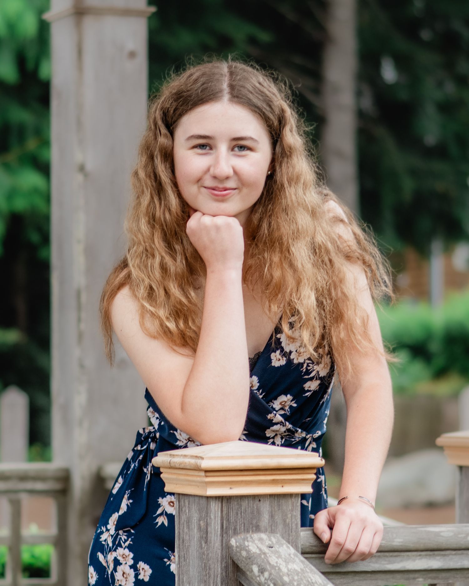 A casual portrait series taken at a wooden post structure outdoors.