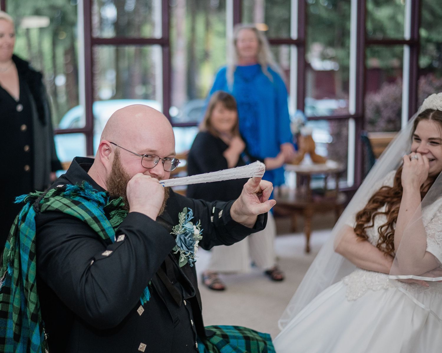Wedding celebration in a church with Scottish kilts and traditional formal attire.