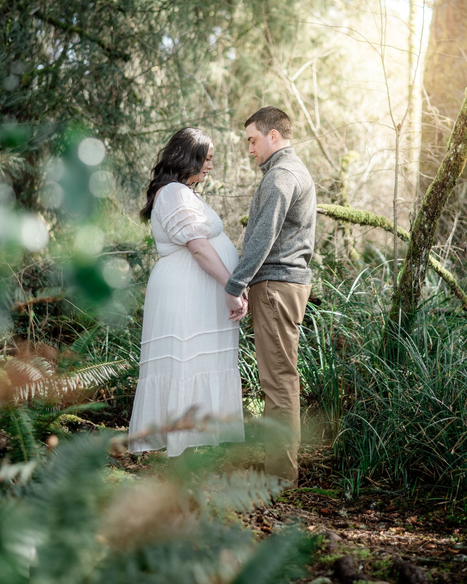 Intimate outdoor couples photography session with soft natural lighting and greenery.