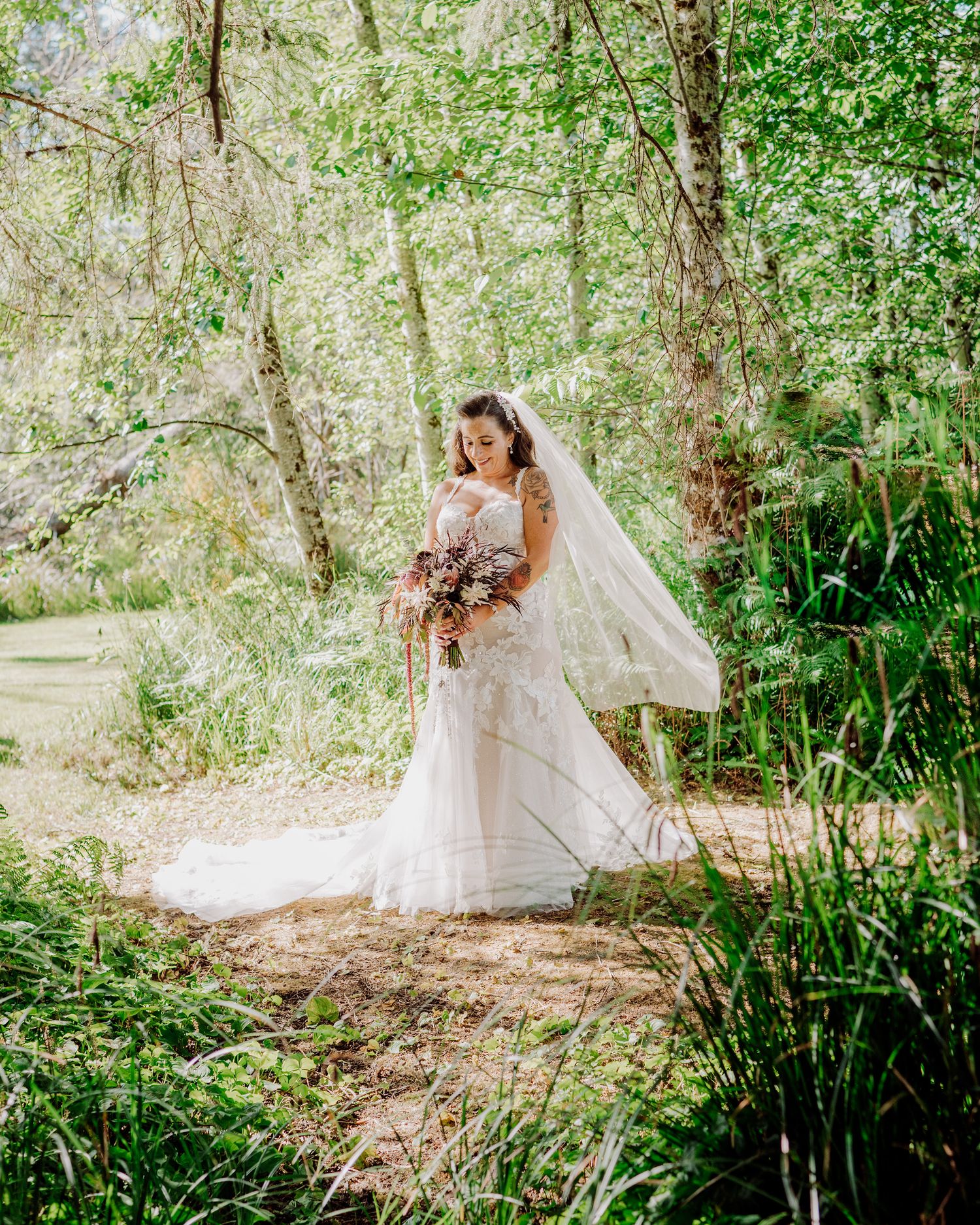 Romantic wedding photos captured on a nature trail with lush greenery and sunlight.