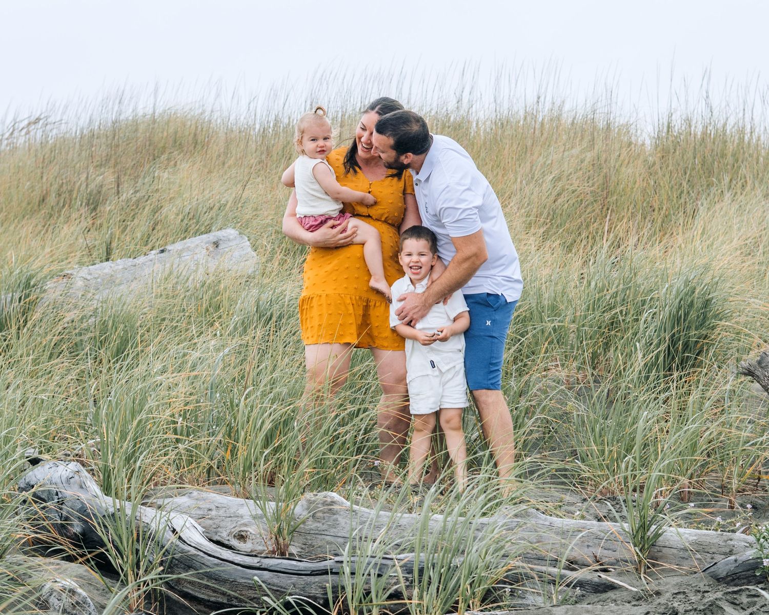 A joyful family moment among coastal dunes and beach grass.