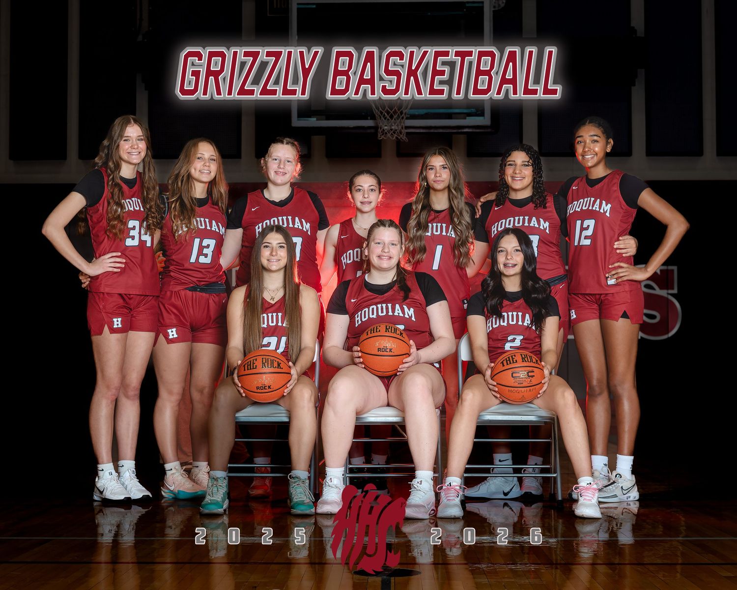 Women's basketball team poses in red uniforms for official team photo.