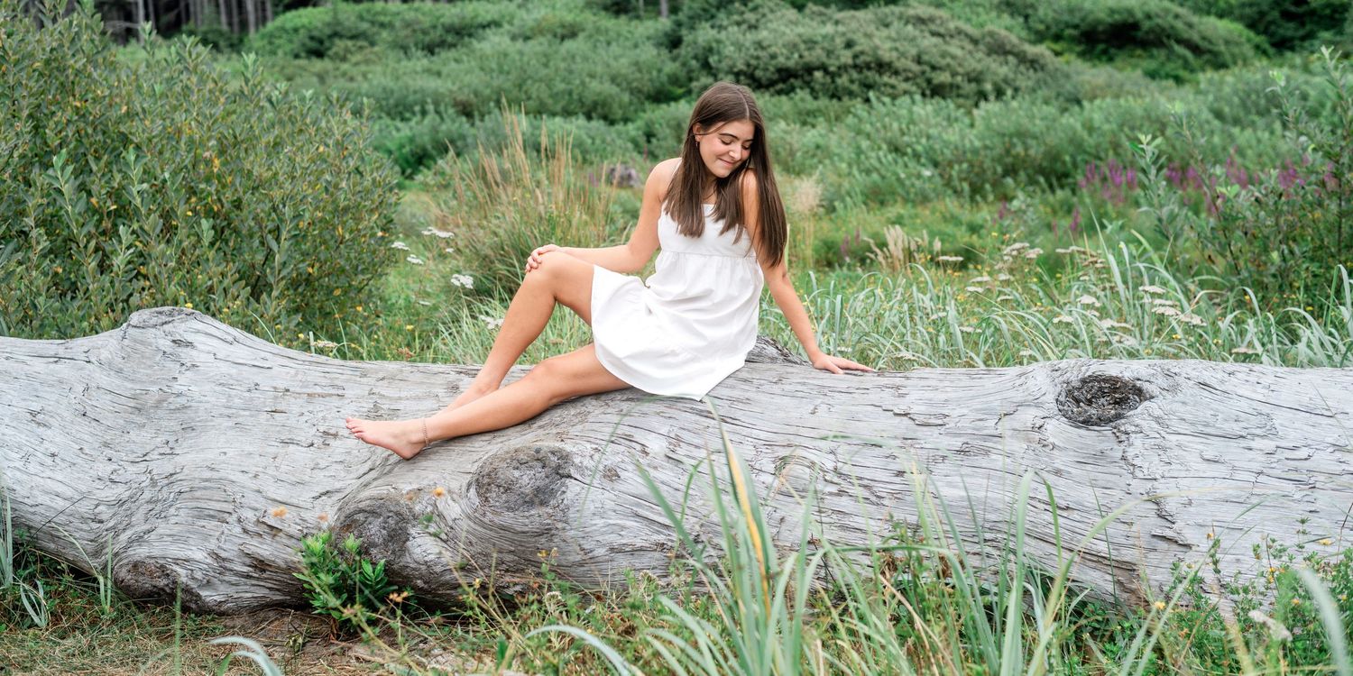 A summer photo session by a stream featuring casual poses on rocks near the water.