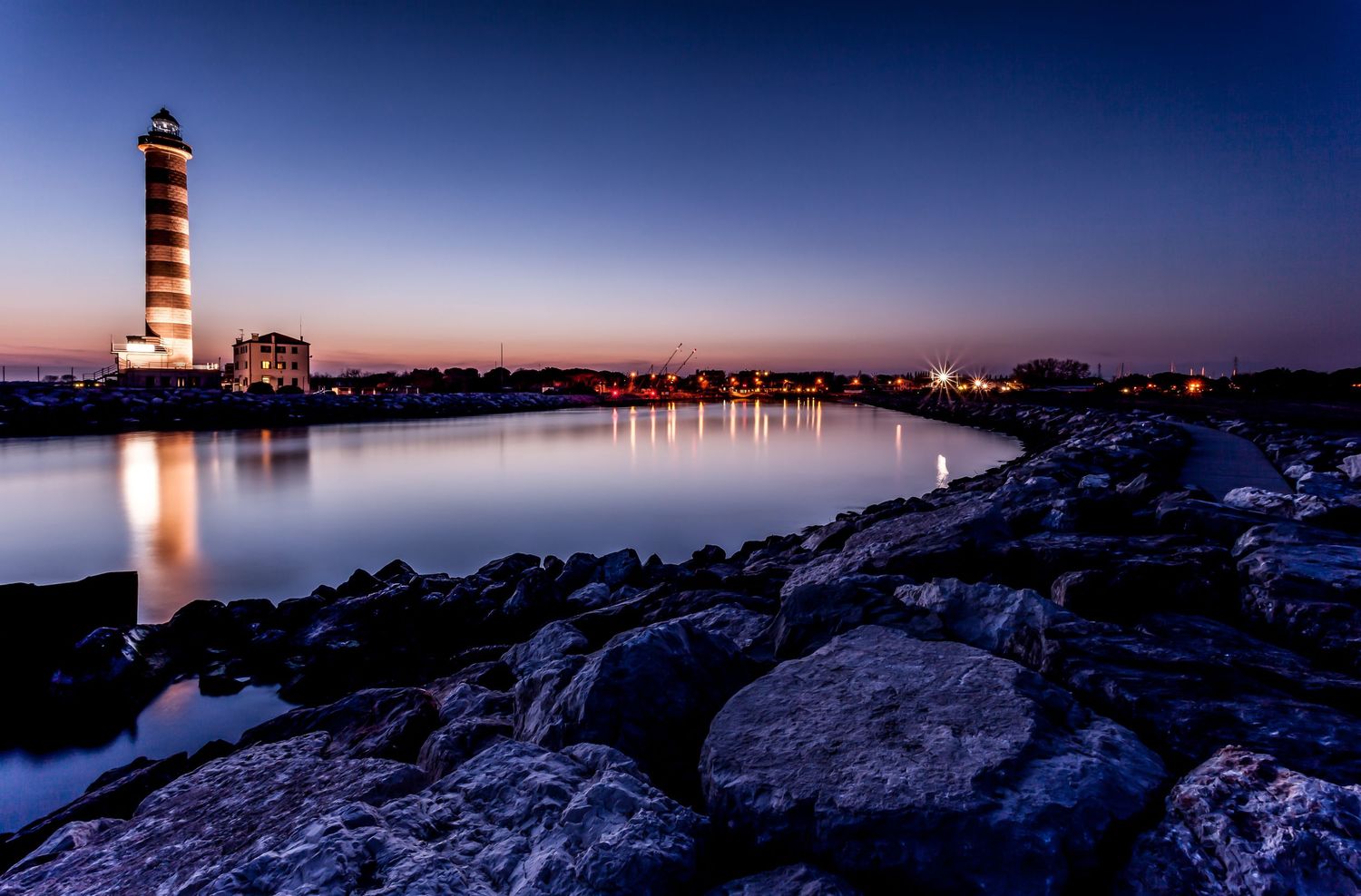 Il Faro di Jesolo – phare majestueux à l’heure bleue, reflet paisible et symétrie sereine sur les eaux tranquilles.