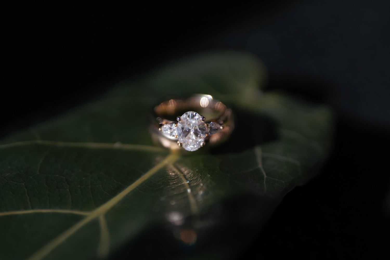A sparkling diamond engagement ring shown in multiple angles against a dark background with selective focus.