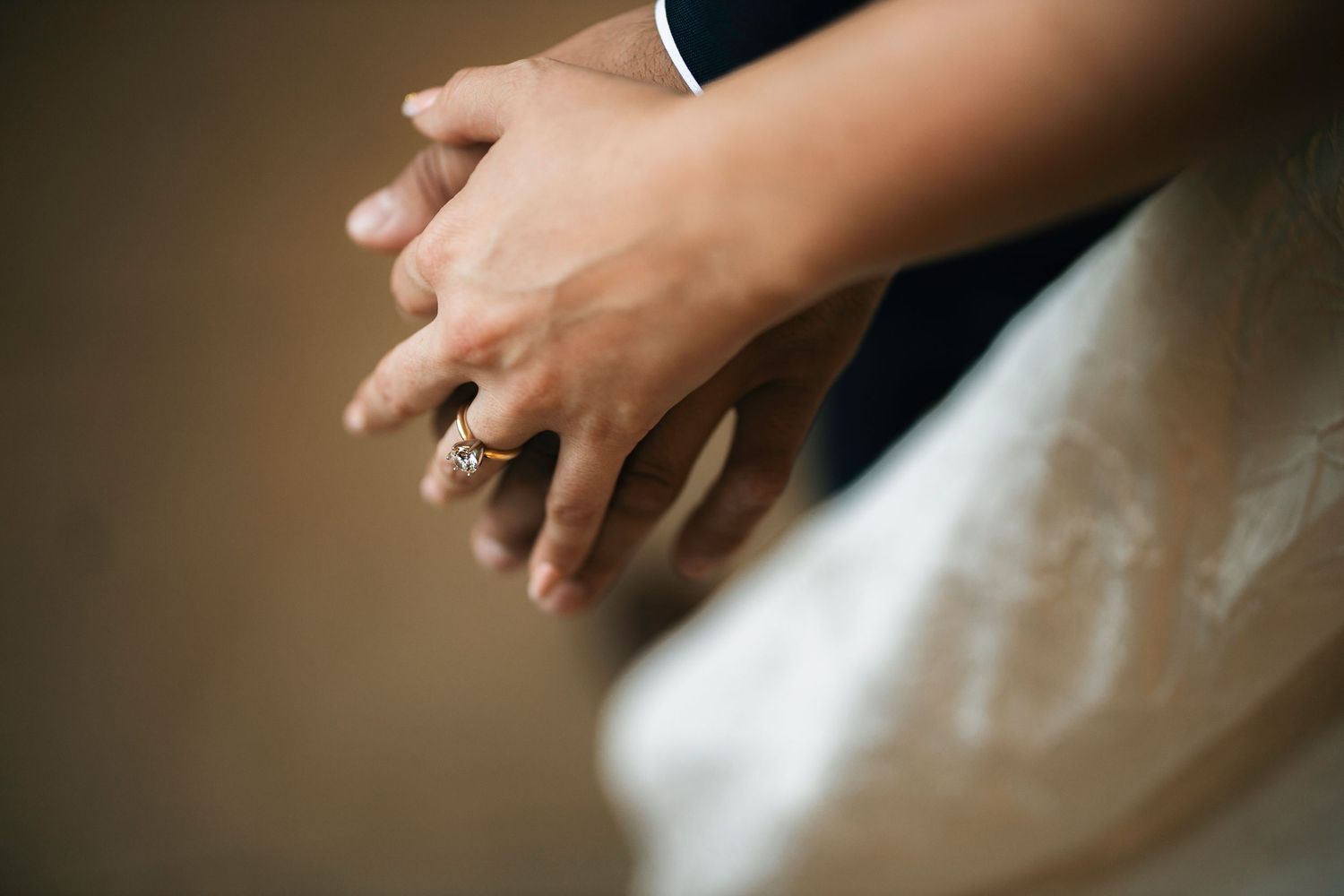 Close-up detail of hands preparing food ingredients on a wooden cutting board in soft natural light.