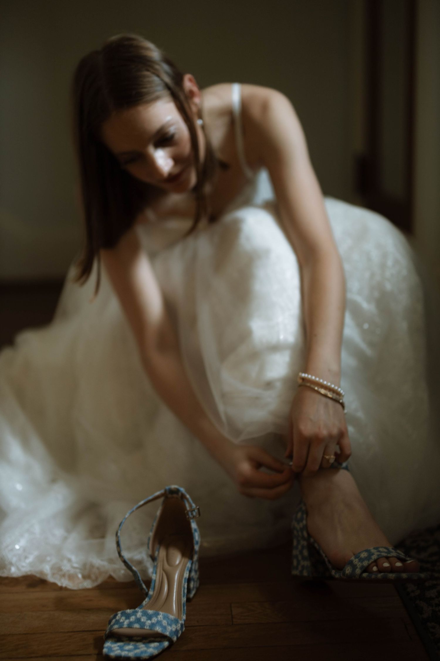 A series of artistic photos showing a person in a white wedding dress adjusting polka dot heels on a wooden floor.
