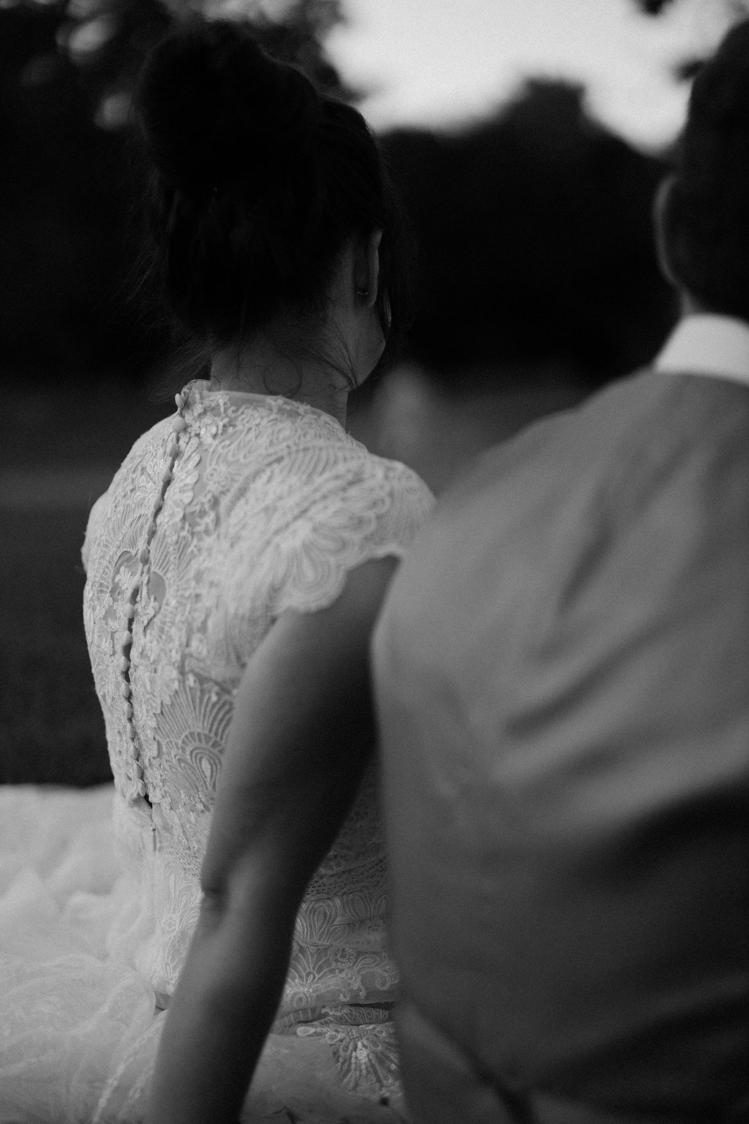 Delicate lace details on a white wedding dress shown in black and white.