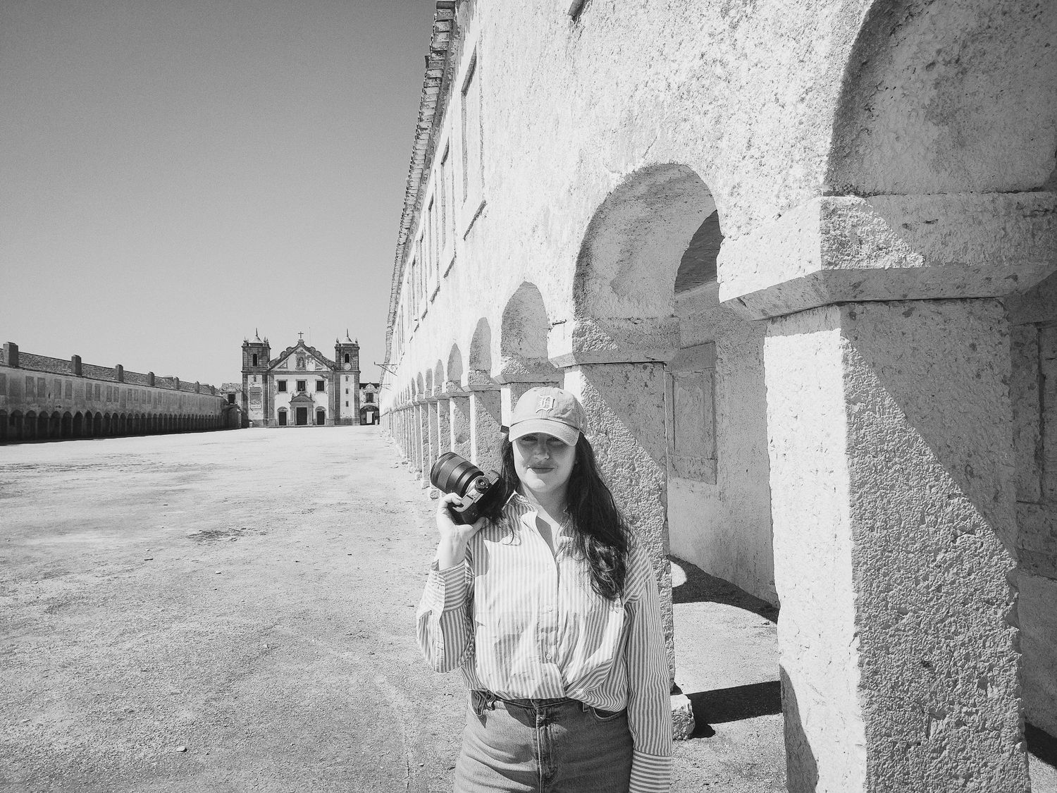 A series of black and white photographs showing a person walking along a white wall casting dramatic shadows in sequence.