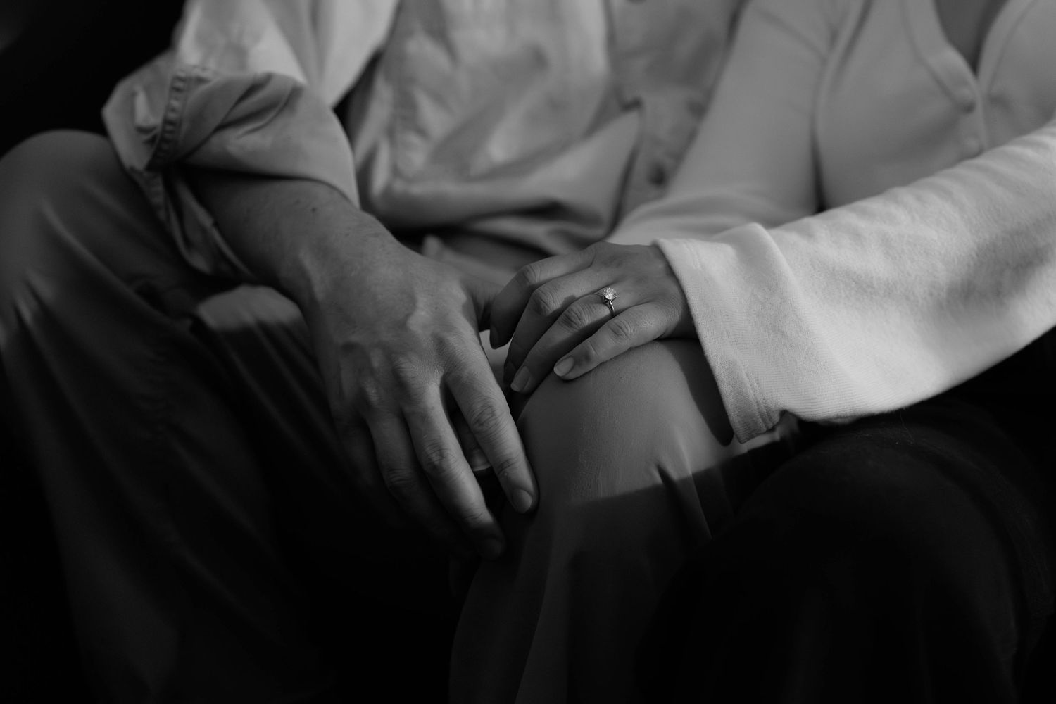 Black and white photo of an elderly couple holding hands, symbolizing love and togetherness.