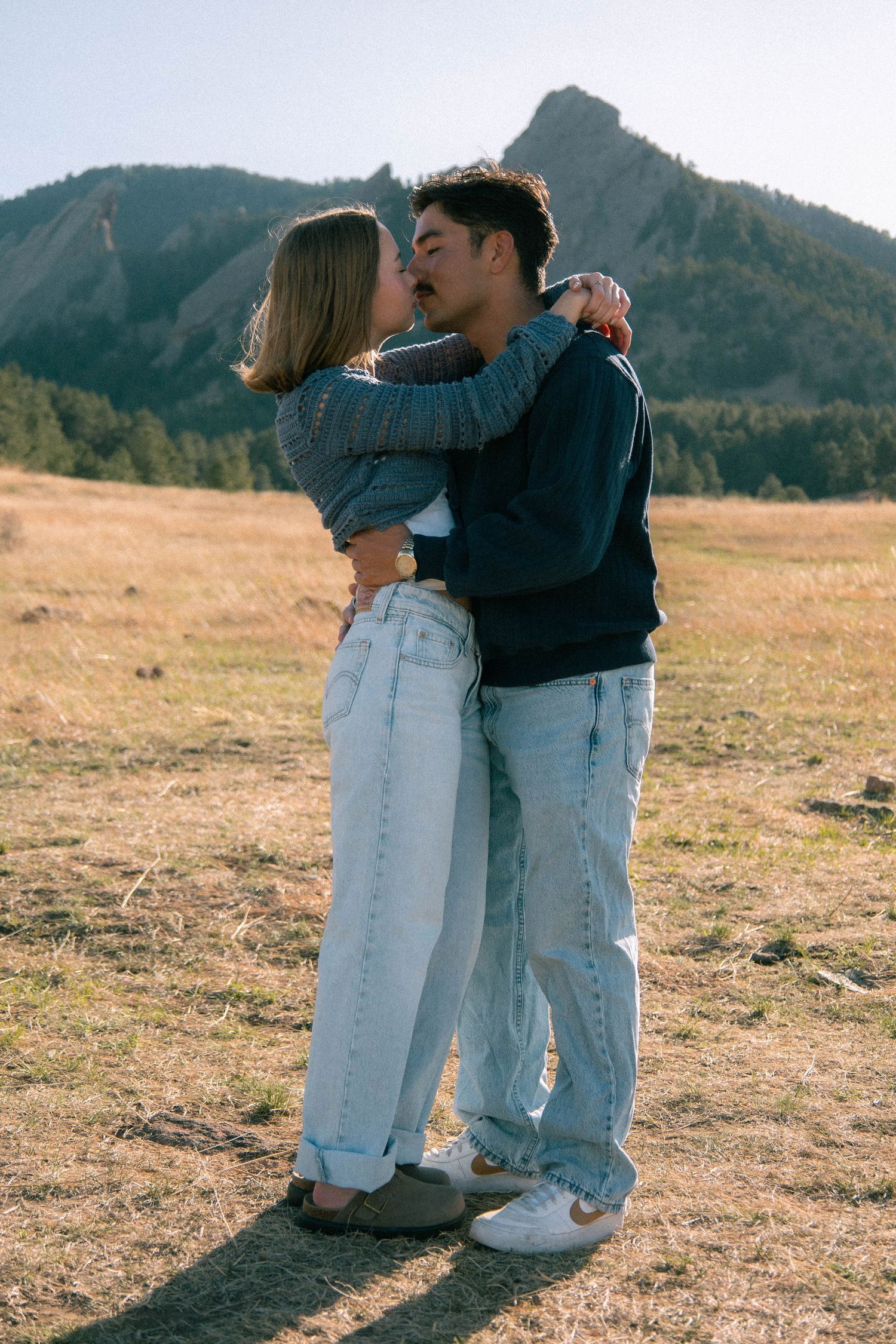 A couple kissing in front of the flatirons in Boulder, Colorado