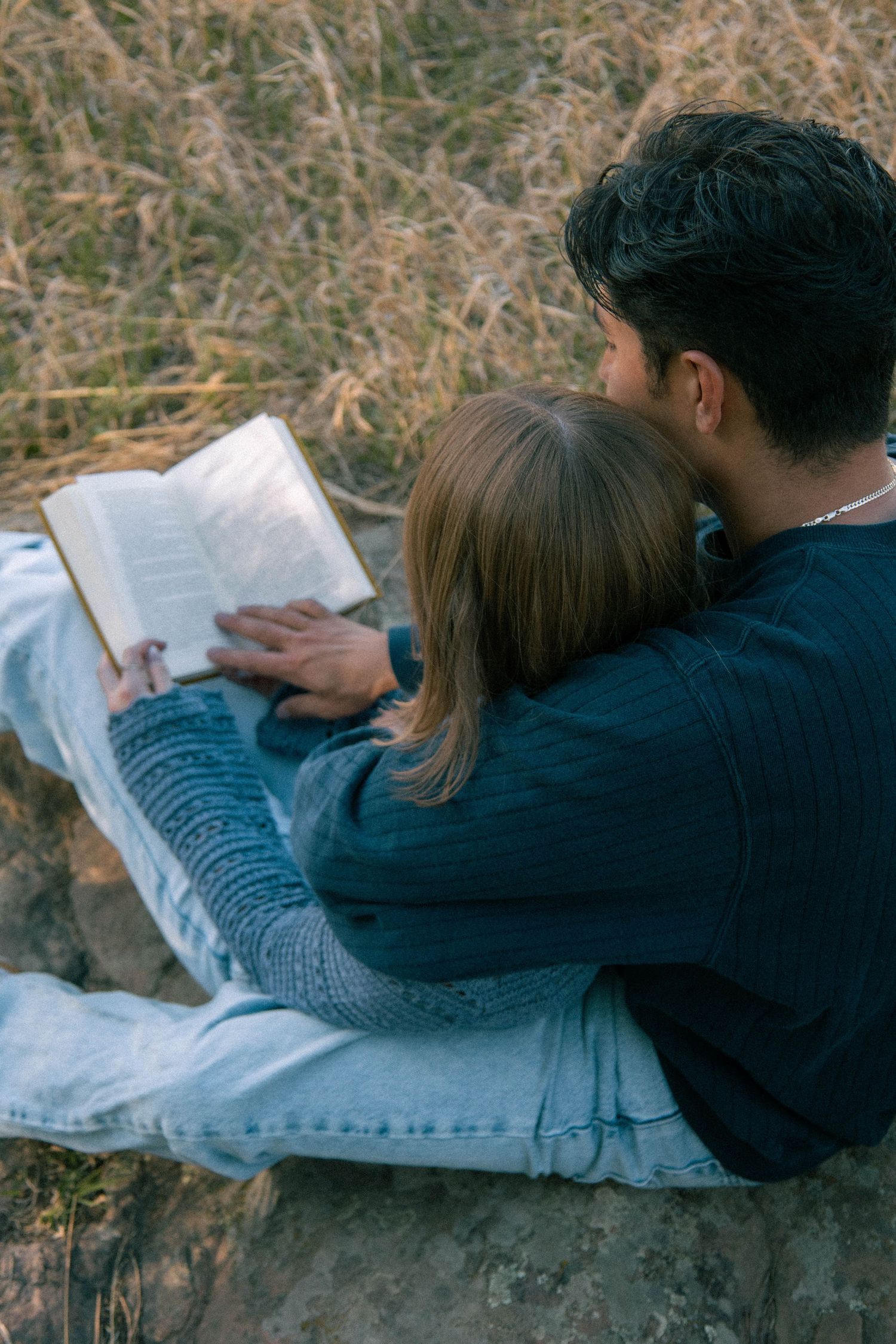 A couple reading together in a grassy field in Boulder, Colorado