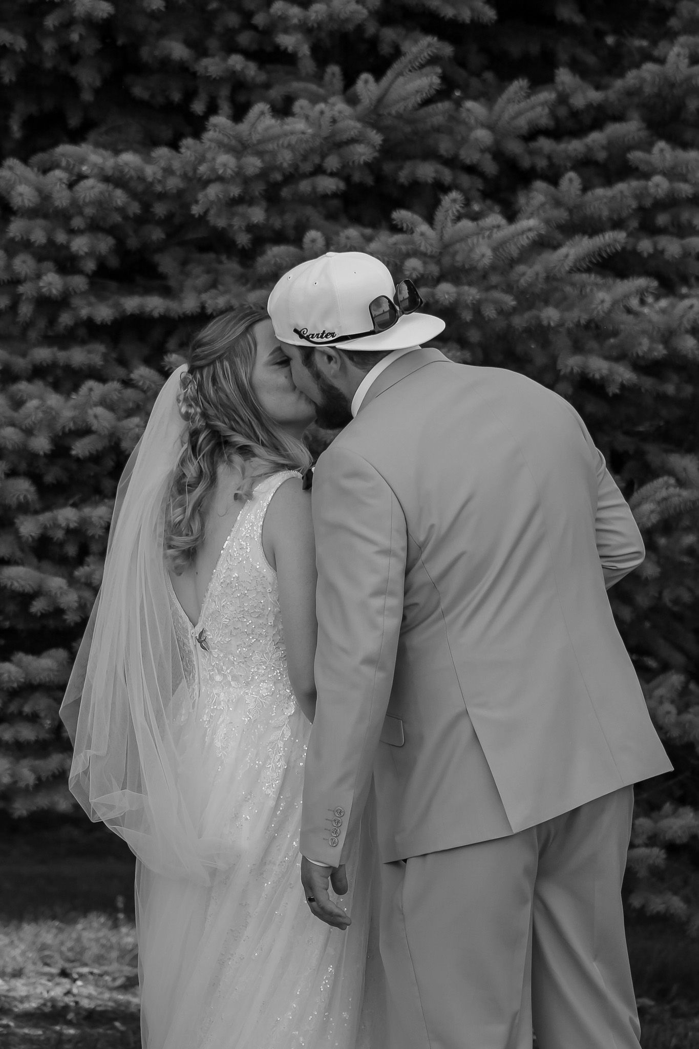 Black and white wedding photos showing a couple walking together through a garden setting.