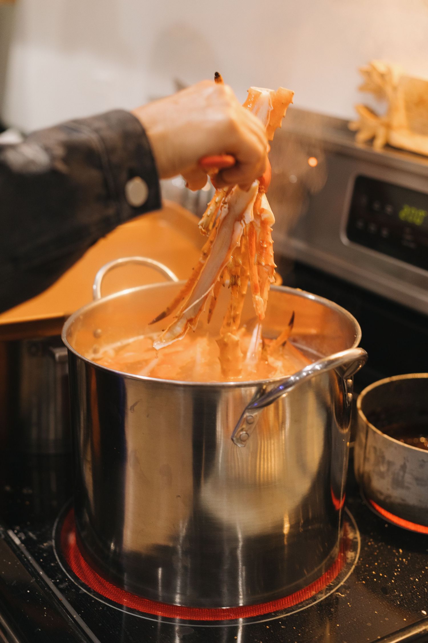 Hot crab legs being pulled from pot showing texture.