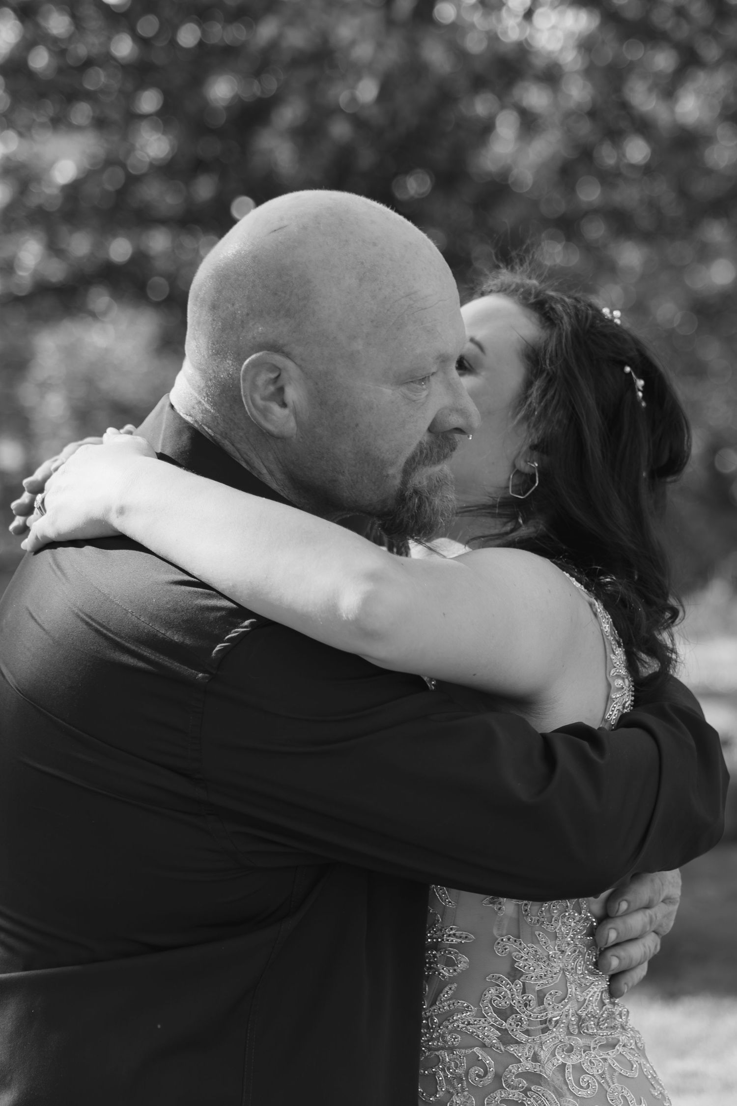 Black and white wedding portrait showing emotional embrace between couple.