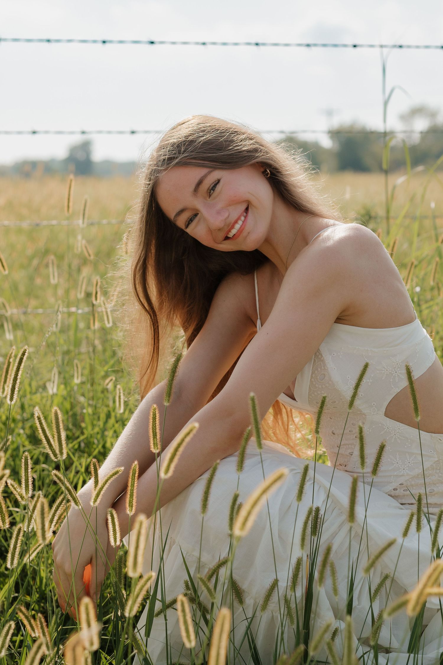 A candid outdoor portrait among golden wheat stalks in a sunny field.