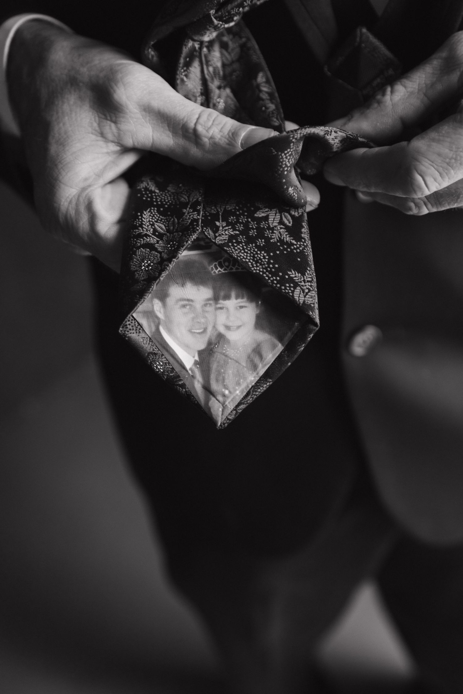 A black and white photograph showing a sentimental photo charm or locket.